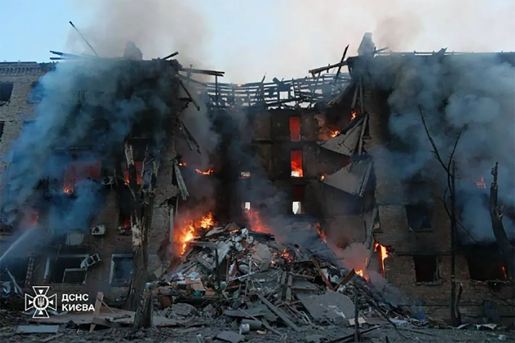 Heavily damaged building engulfed in fire and smoke following a Russian strike on Kyiv.