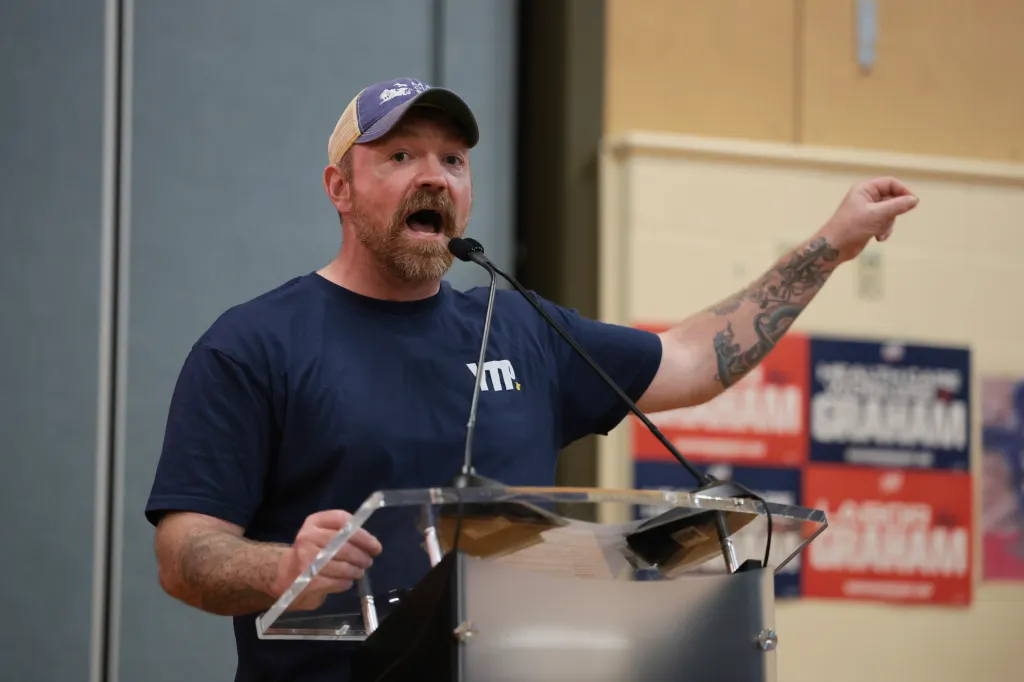 Democratic U.S. Senate candidate Graham Platner speaks into a microphone at a town hall.