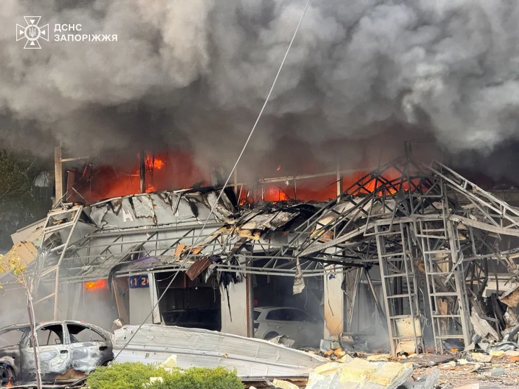 Aftermath of a Russian air attack in Zaporizhzhia, showing a heavily damaged building engulfed in flames and smoke.
