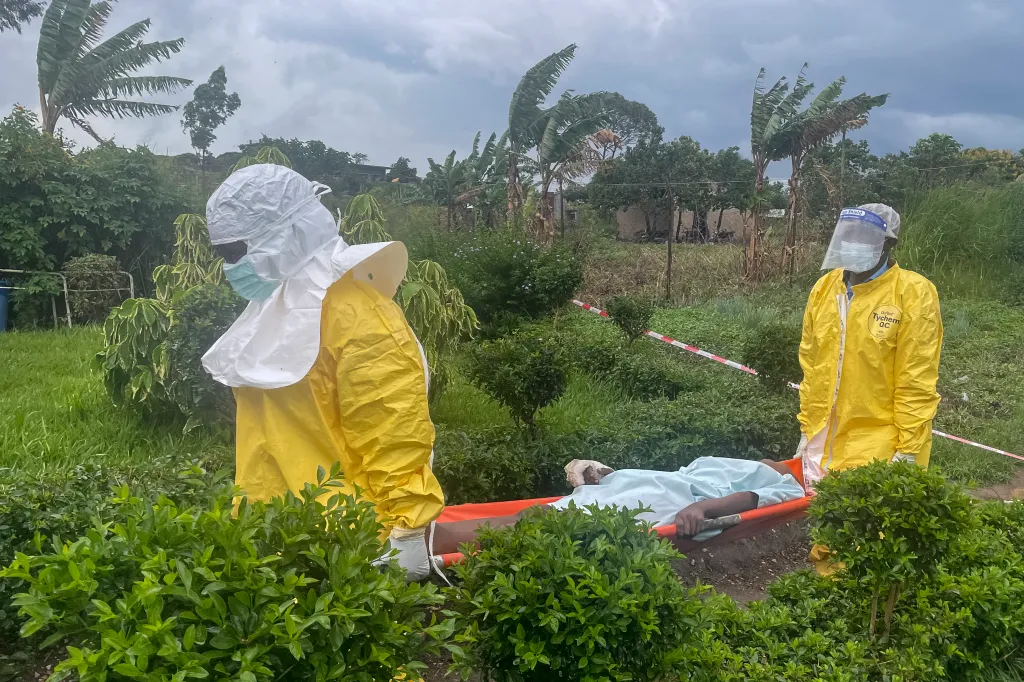 Medical staff in PPE carrying a patient on a stretcher.