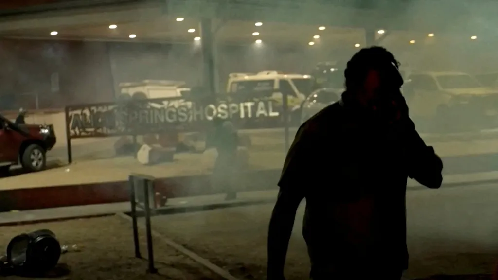 A man walks through tear gas outside Alice Springs Hospital.