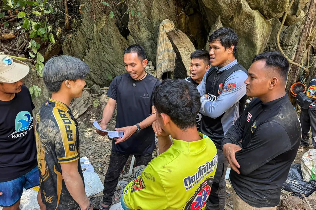 Rescuers use a laptop and two-way radio to coordinate efforts to reach people trapped in a cave in Xaisomboun province, Laos.
