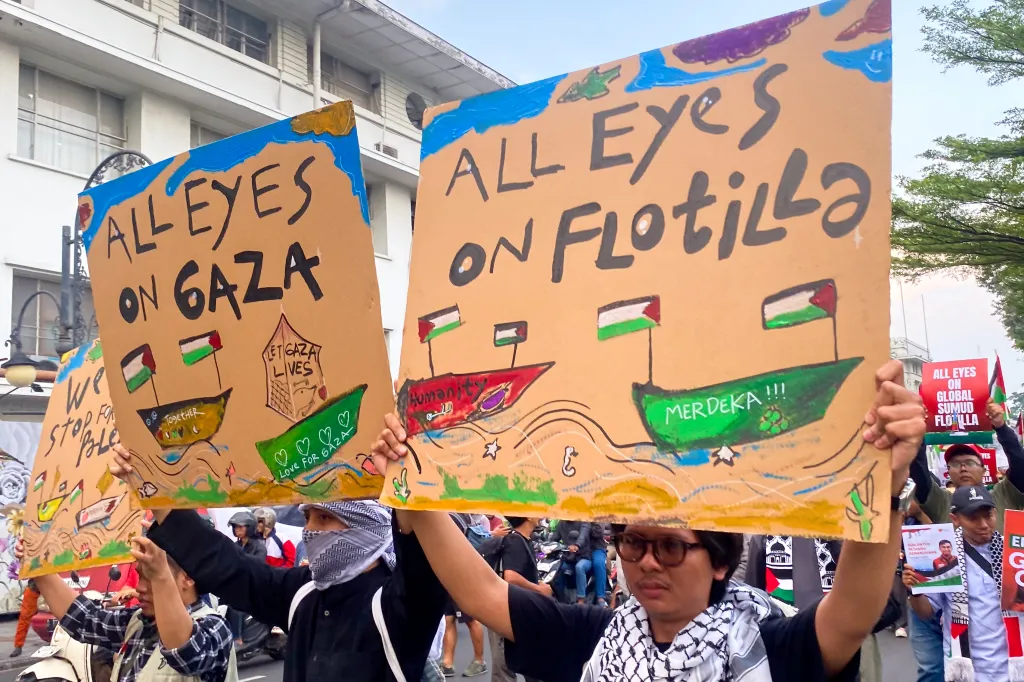 Activists in Bandung City hold signs saying 