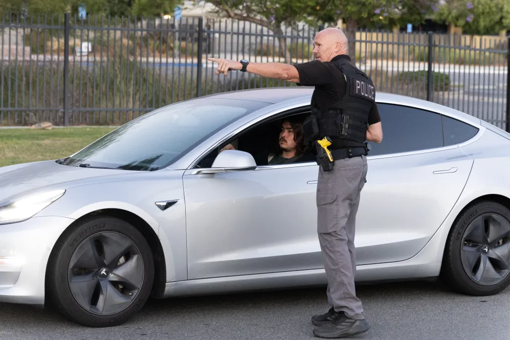 Police officer directing a driver to an evacuation shelter during a chemical leak incident.