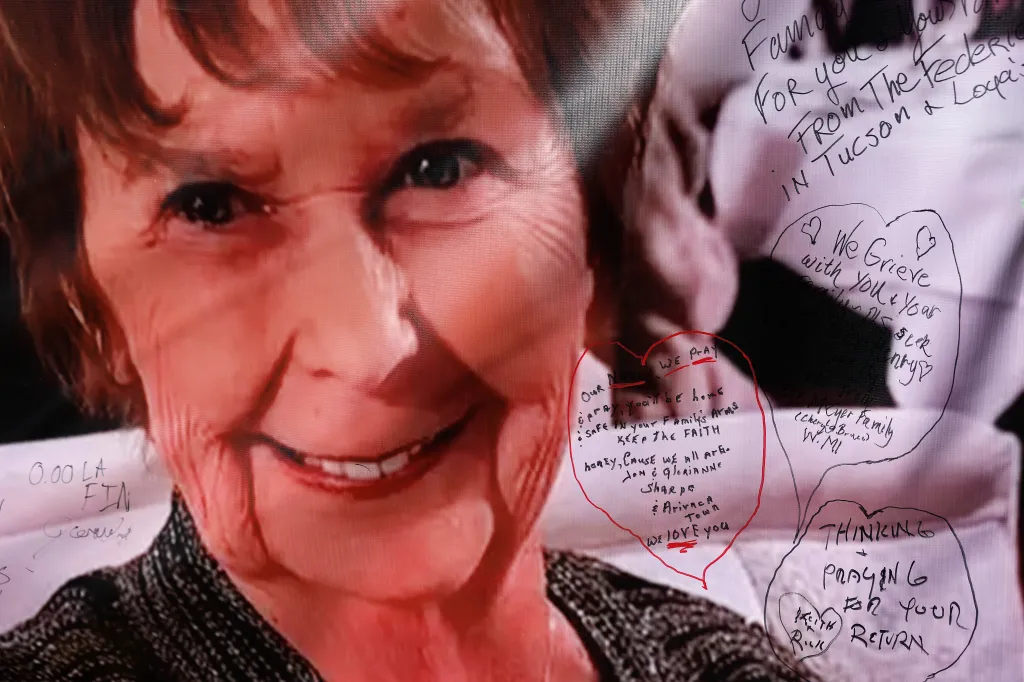 A photo of Nancy Guthrie on display at a TV station with handwritten notes and prayers from the public.