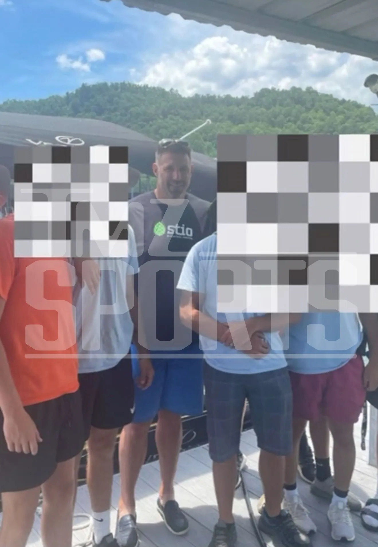 Mike Vrabel smiling in a group photo on a boat.