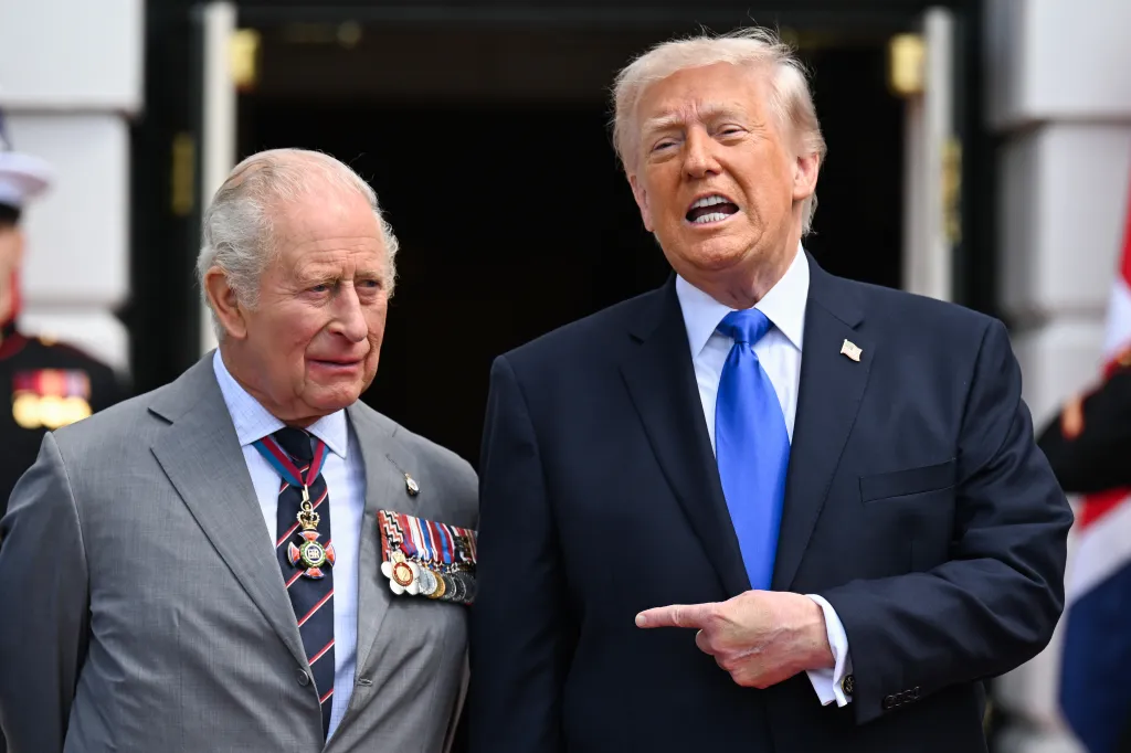 King Charles III and Donald Trump standing together with Trump speaking and pointing to his right.