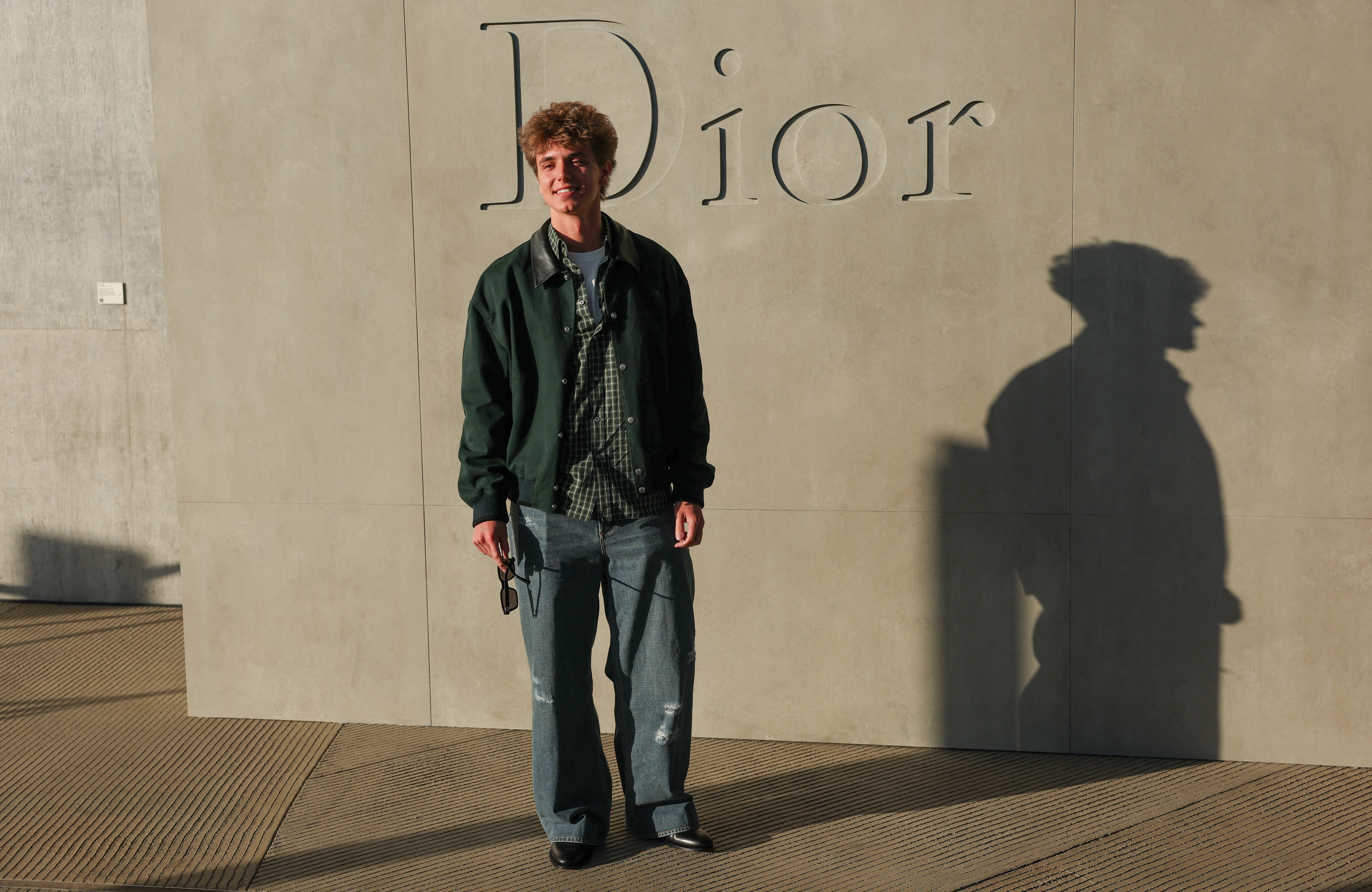 Jayden James Federline standing in front of a Dior sign.
