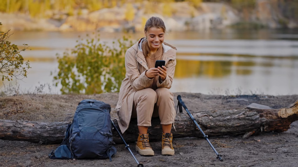 A female student outdoors using her phone to study with the SOAR program.