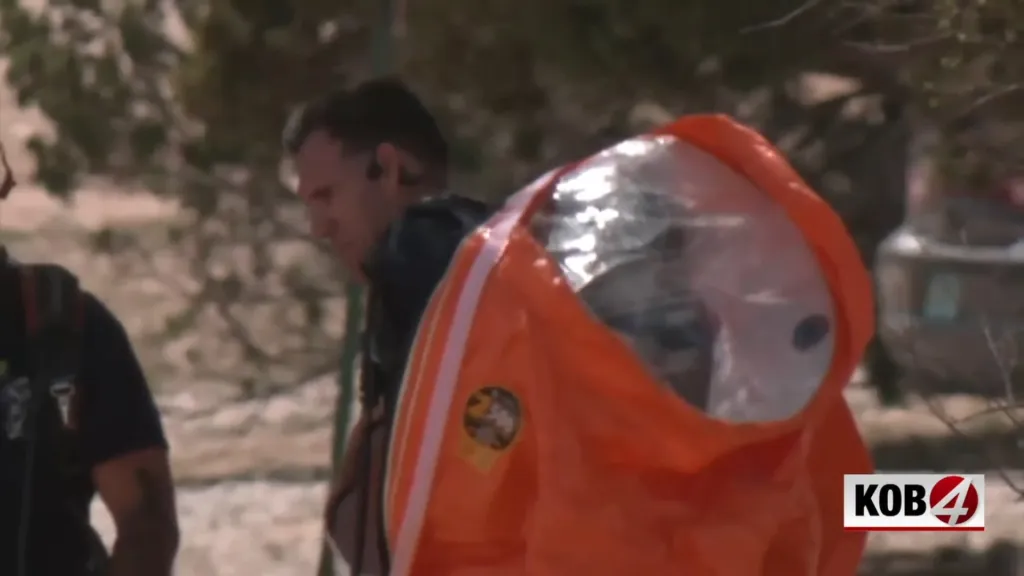 First responder in an orange hazmat suit with a clear hood.
