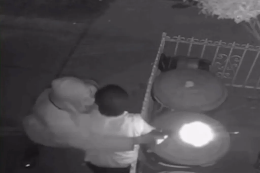 Surveillance footage shows a person in a white hooded sweatshirt and black pants shooting at a grill, illuminating a bright light.