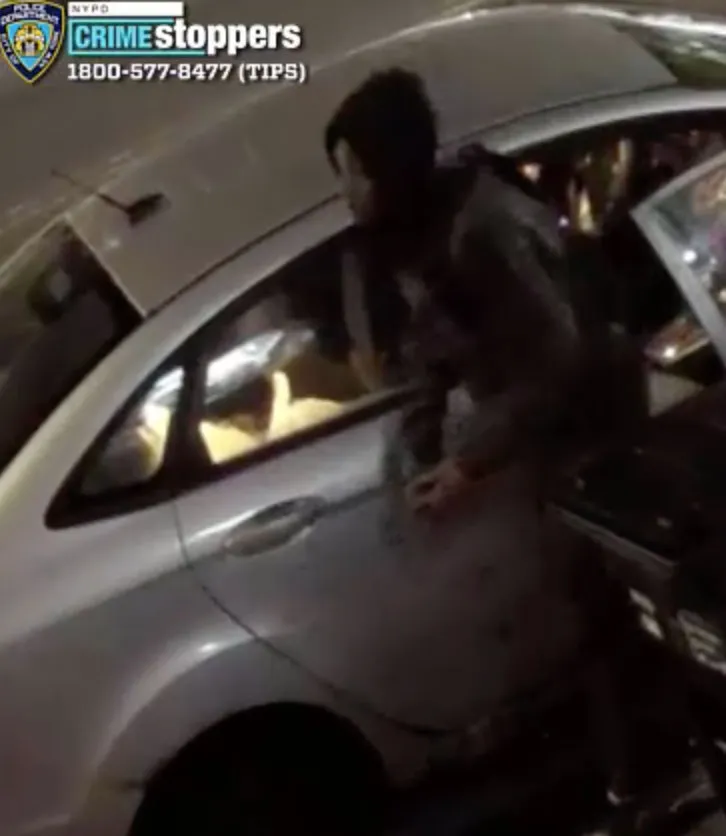 Still from surveillance video of an individual fleeing a vehicle, wanted in connection with a robbery.