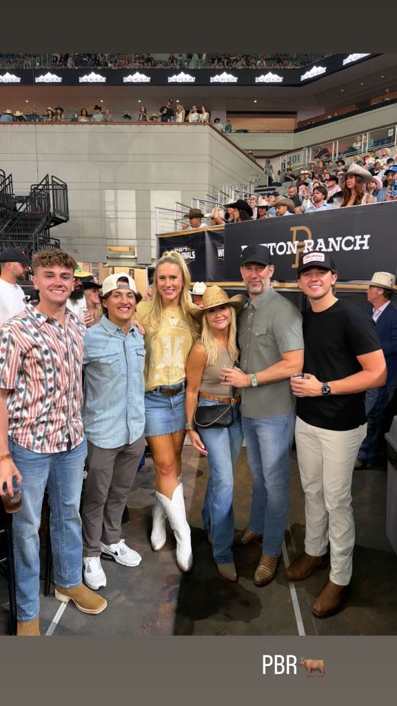 Six people posing in front of a PBR event banner.
