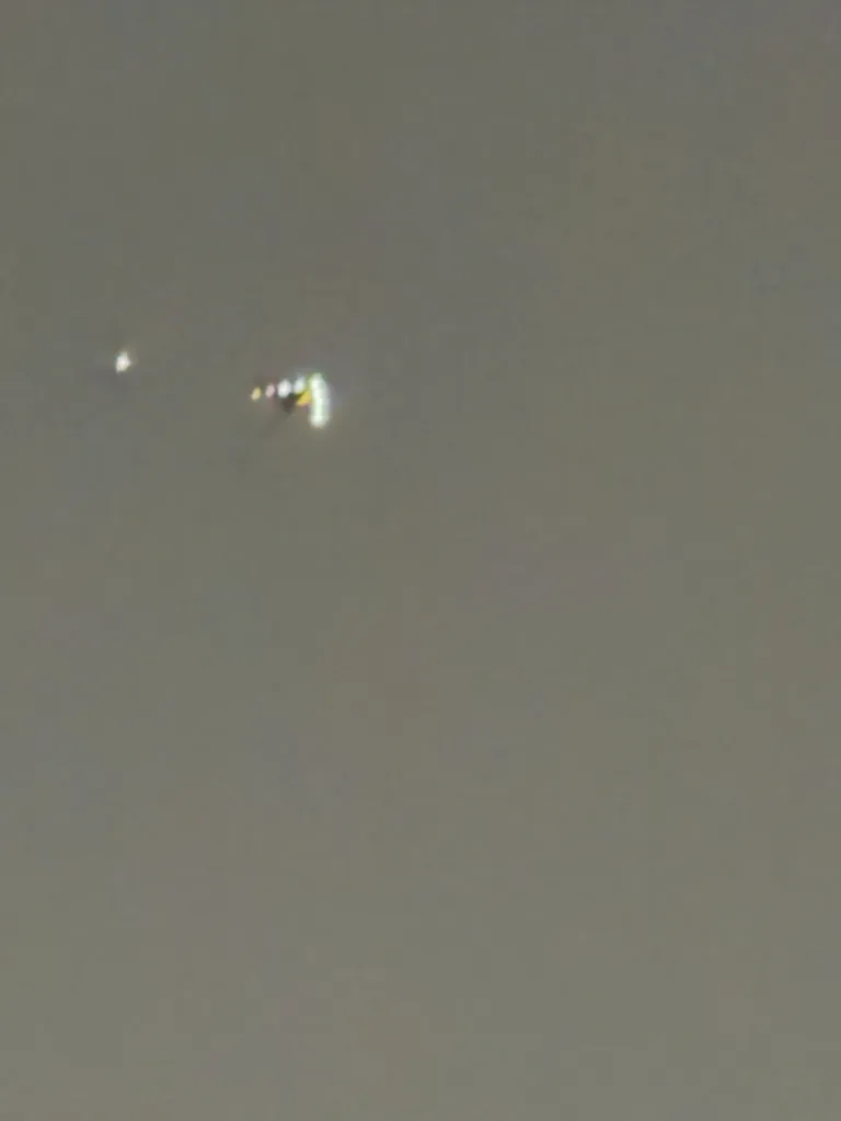 Out-of-focus image of a light anomaly against a gray sky.