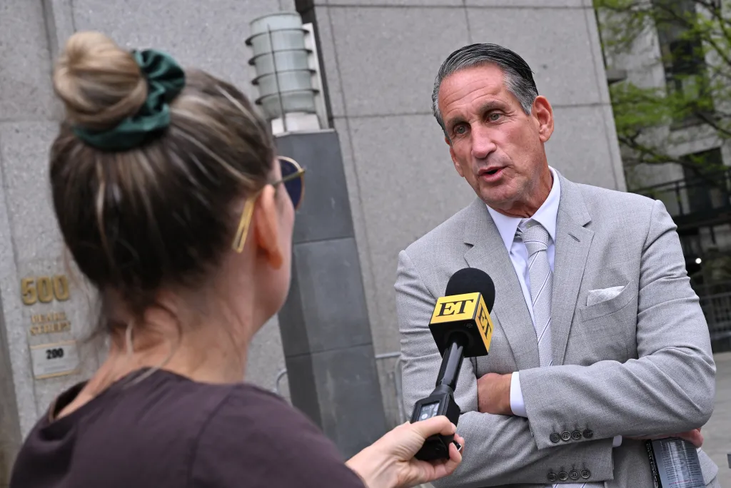 Bryan Freedman, Justin Baldoni's attorney, speaks into an Entertainment Tonight microphone held by a reporter outside the Manhattan Federal Courthouse.