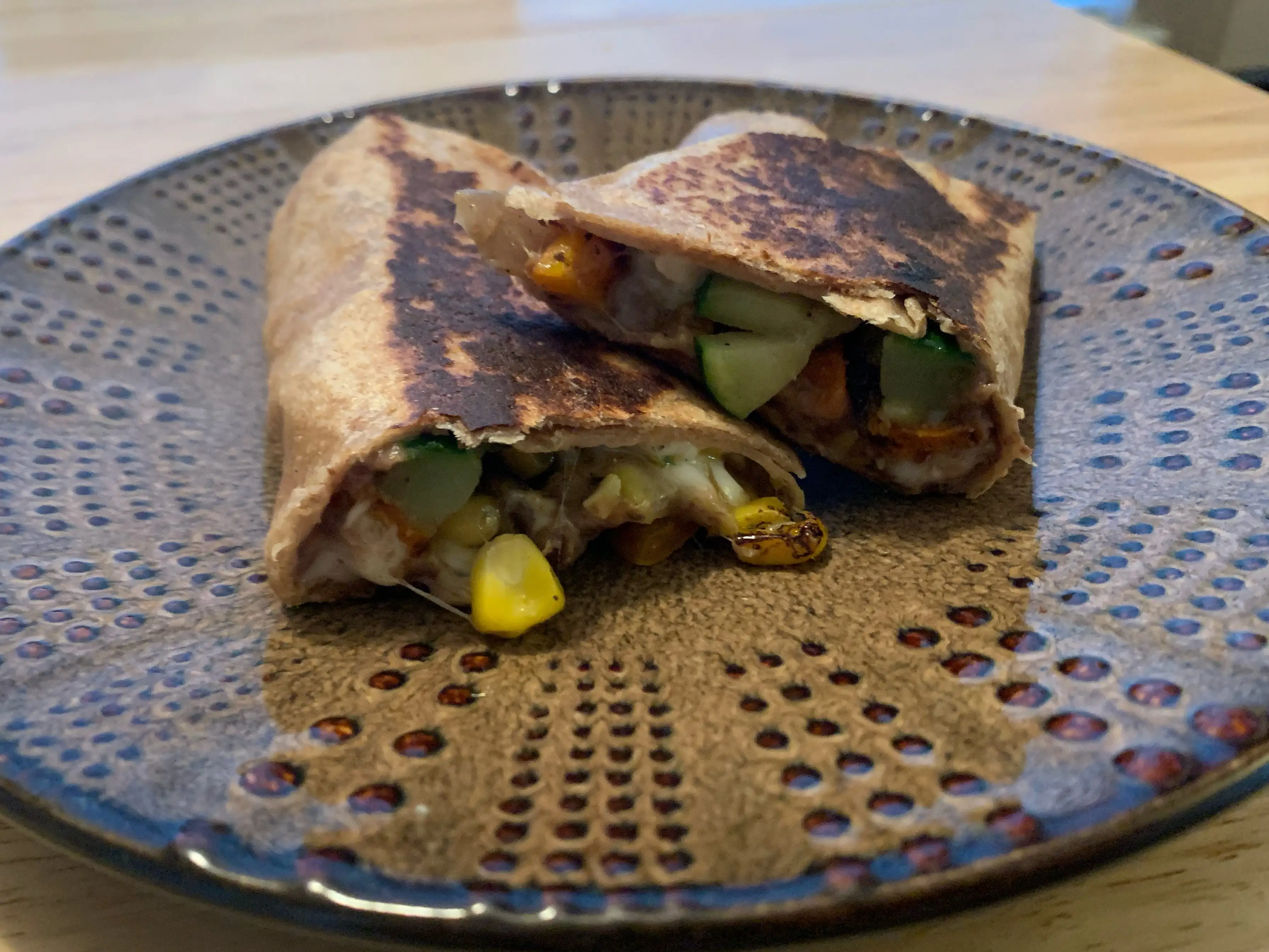 burrito cut in half on brown plate