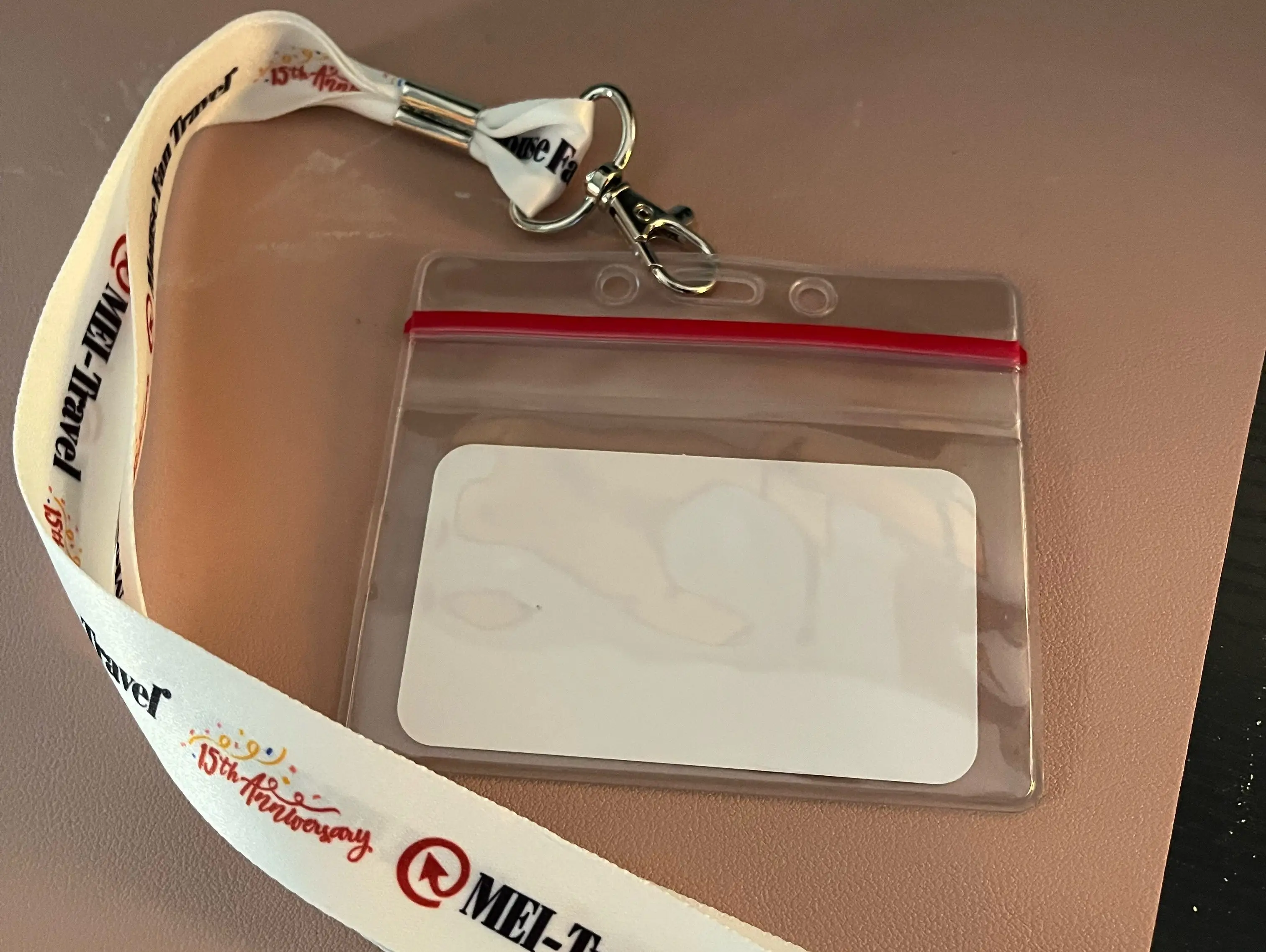 white lanyard with clear card case on a table