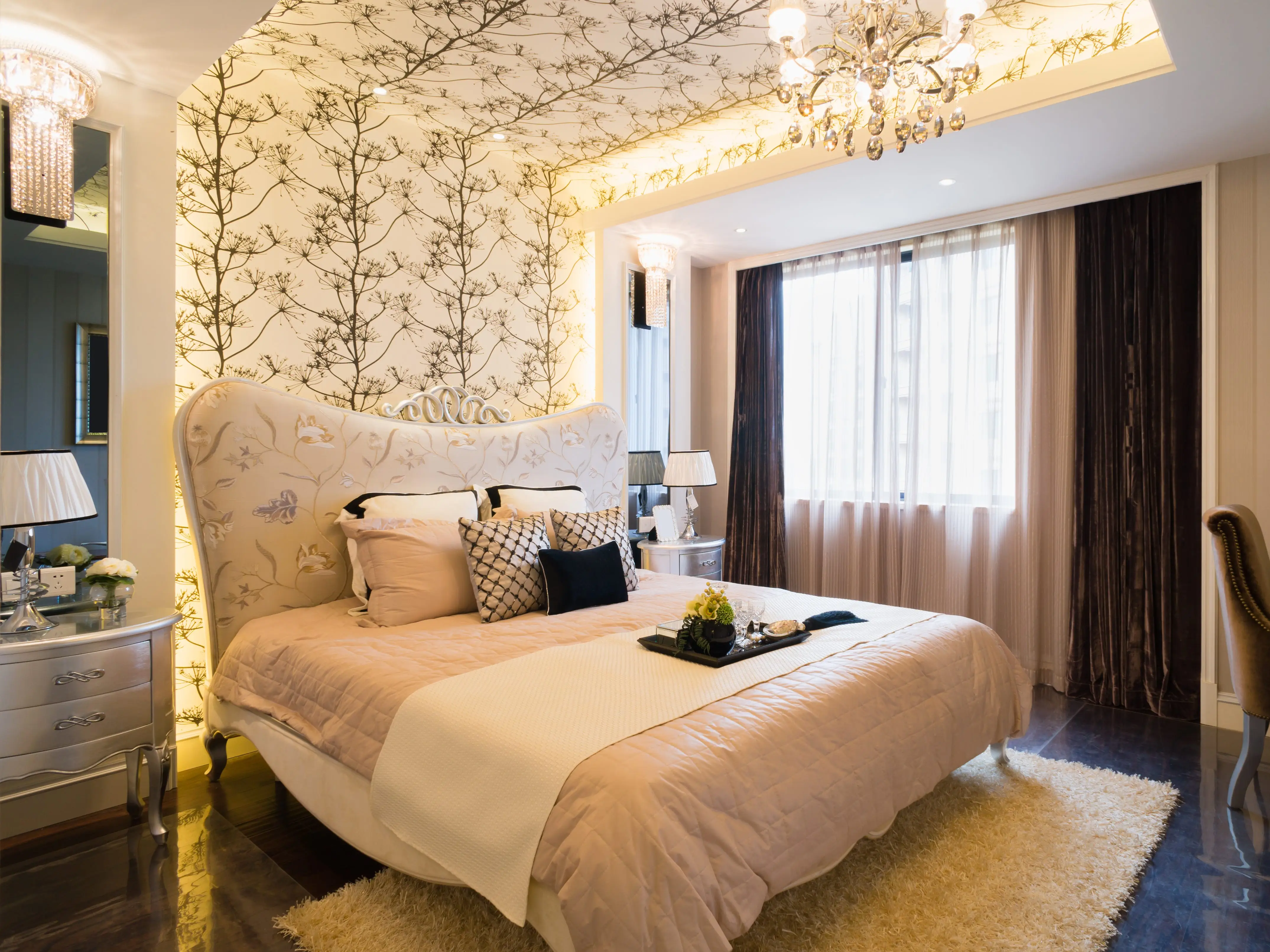 bedroom with white bed, white rug, curtains, and black and white wallpaper