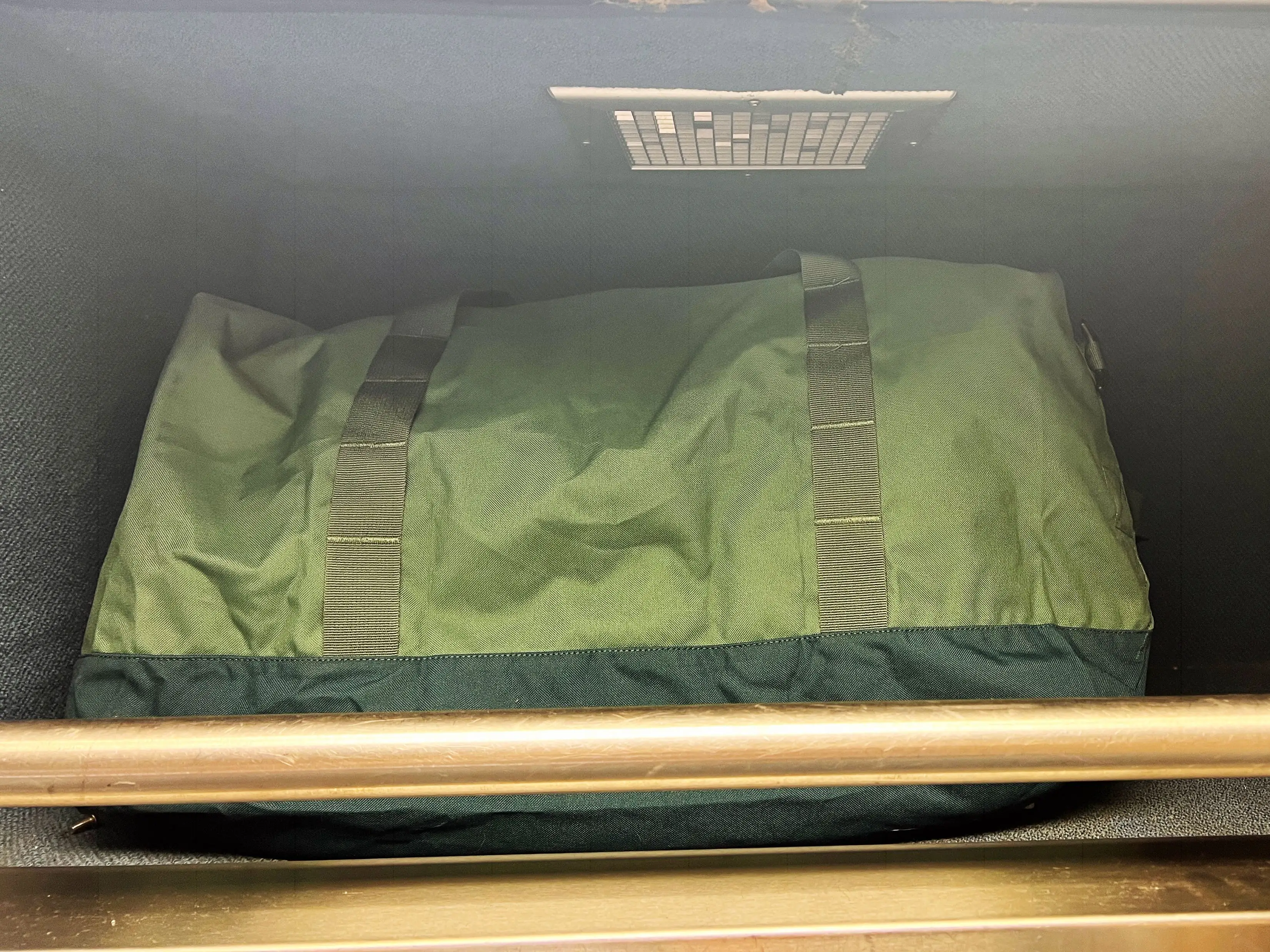 A green bag stored inside the luggage section in the author's Amtrak roomette.