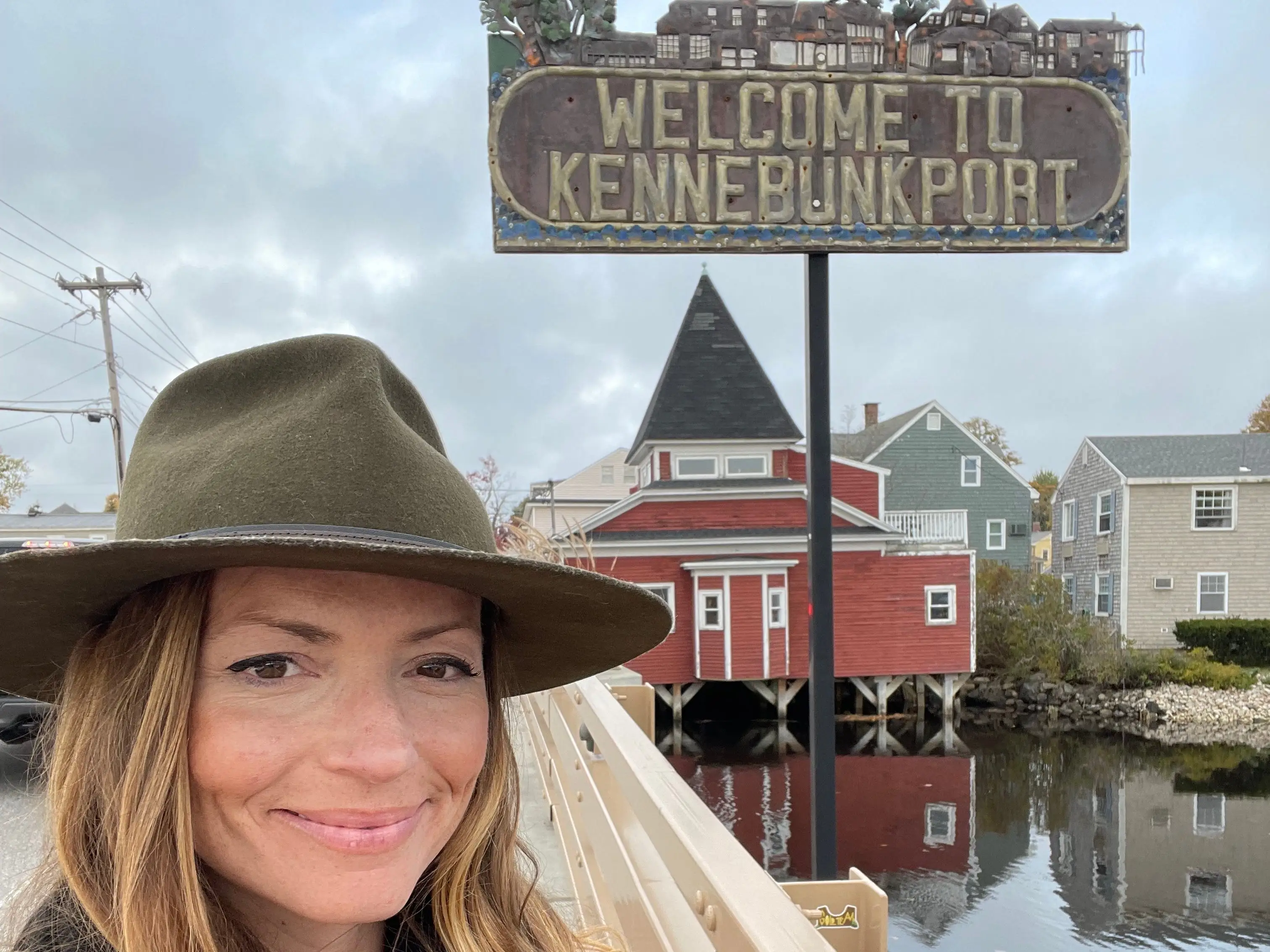 Emily taking a selfie in front of a sign that says 