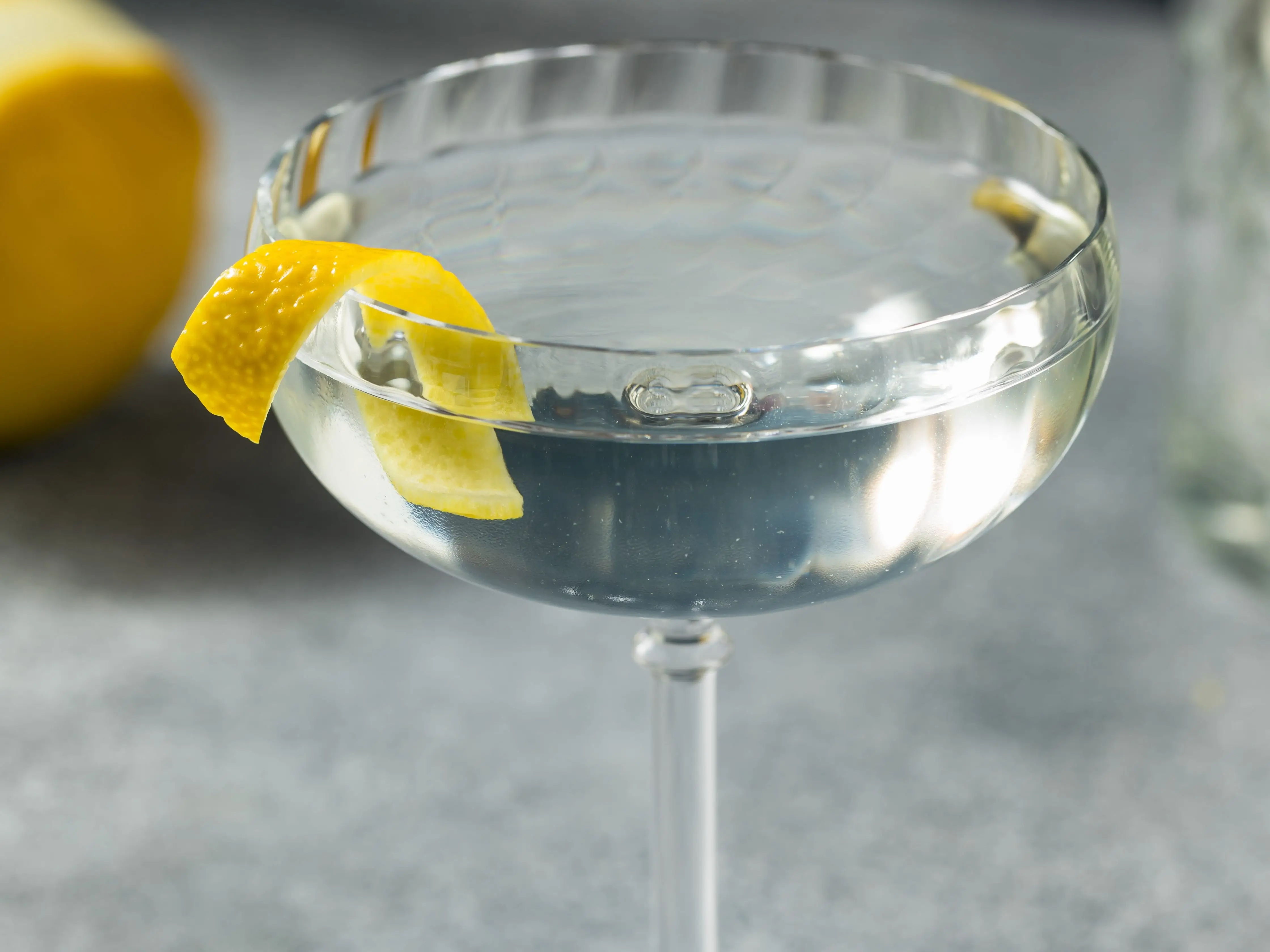 A 50/50 gin martini in a glass with a lemon shaving inside.