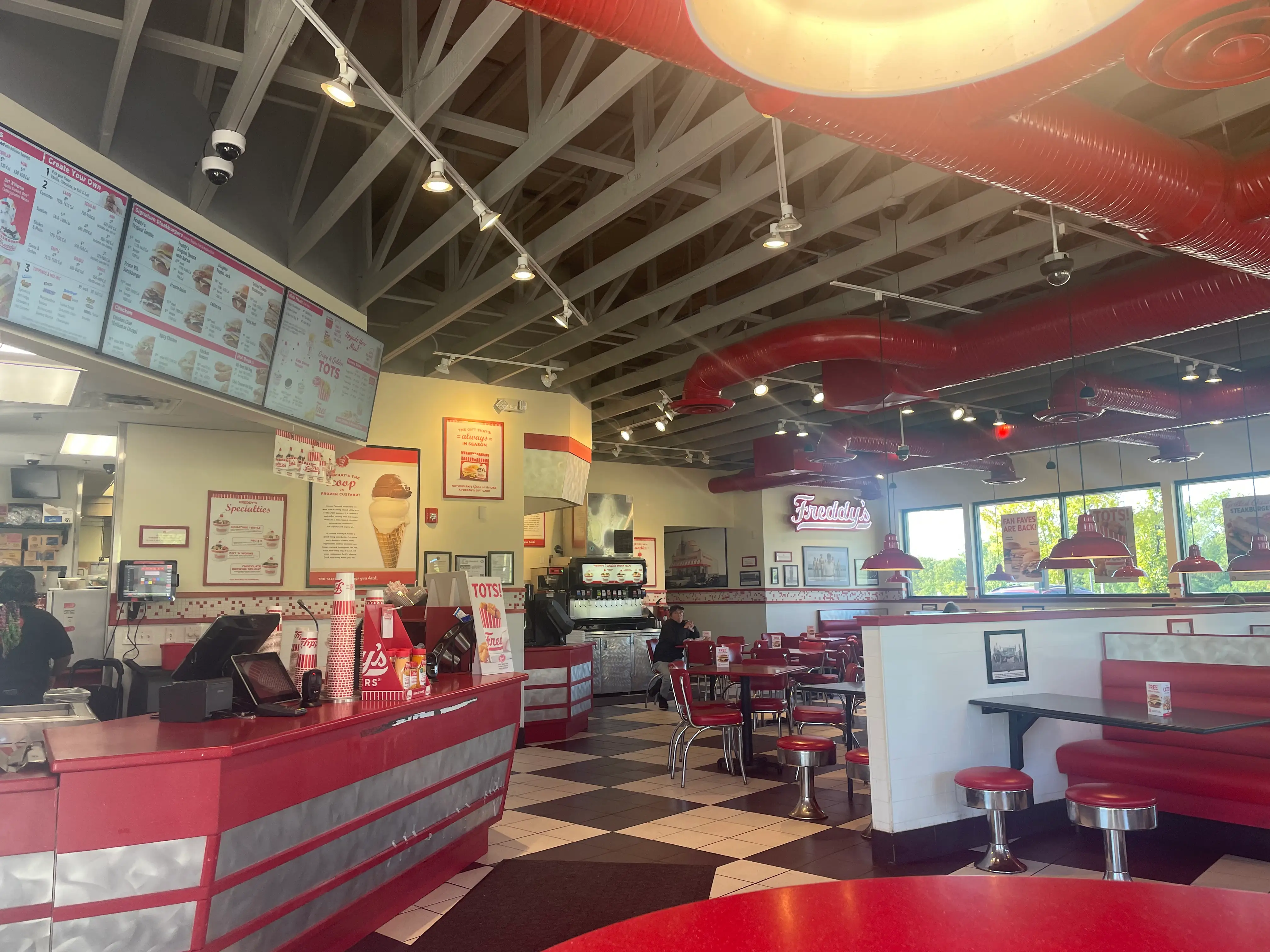 Inside a Freddy's restaurant with red accents and a black-and-white chequered floor.