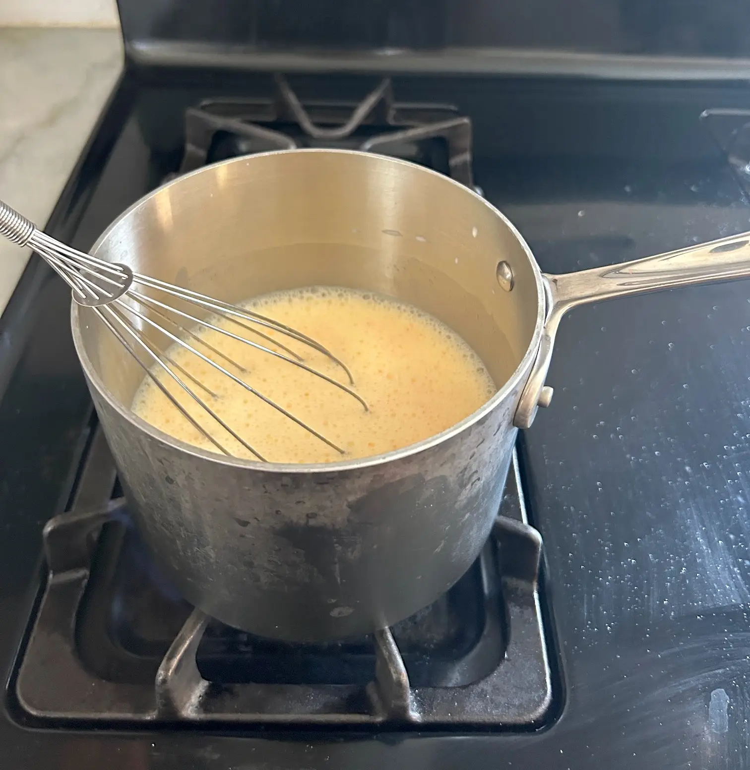 Whisking pudding on the stove for Meghan Markle's Chantilly Lily