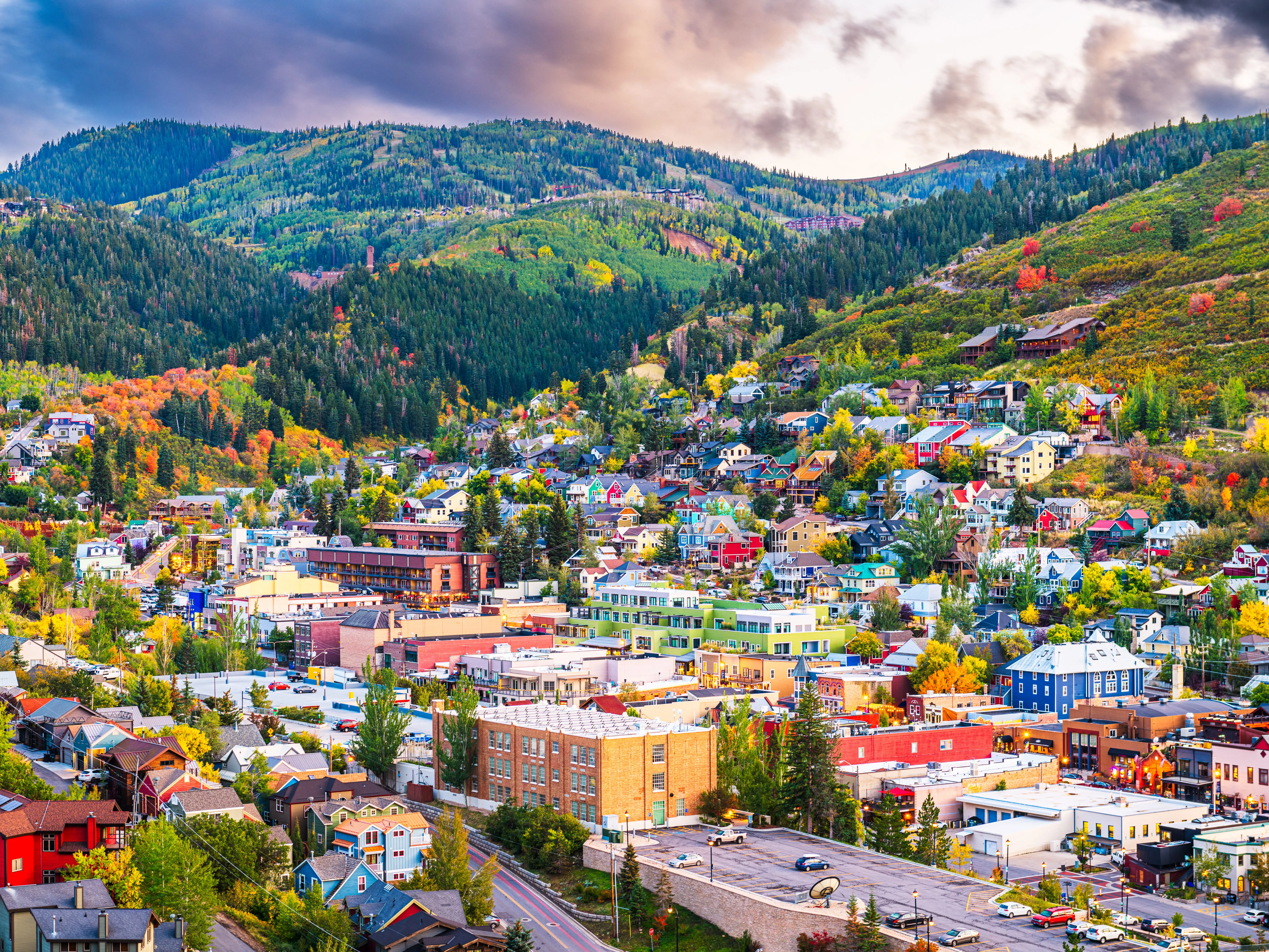 An overview of Park City, Utah, dotted with trees and with mountains behind it.