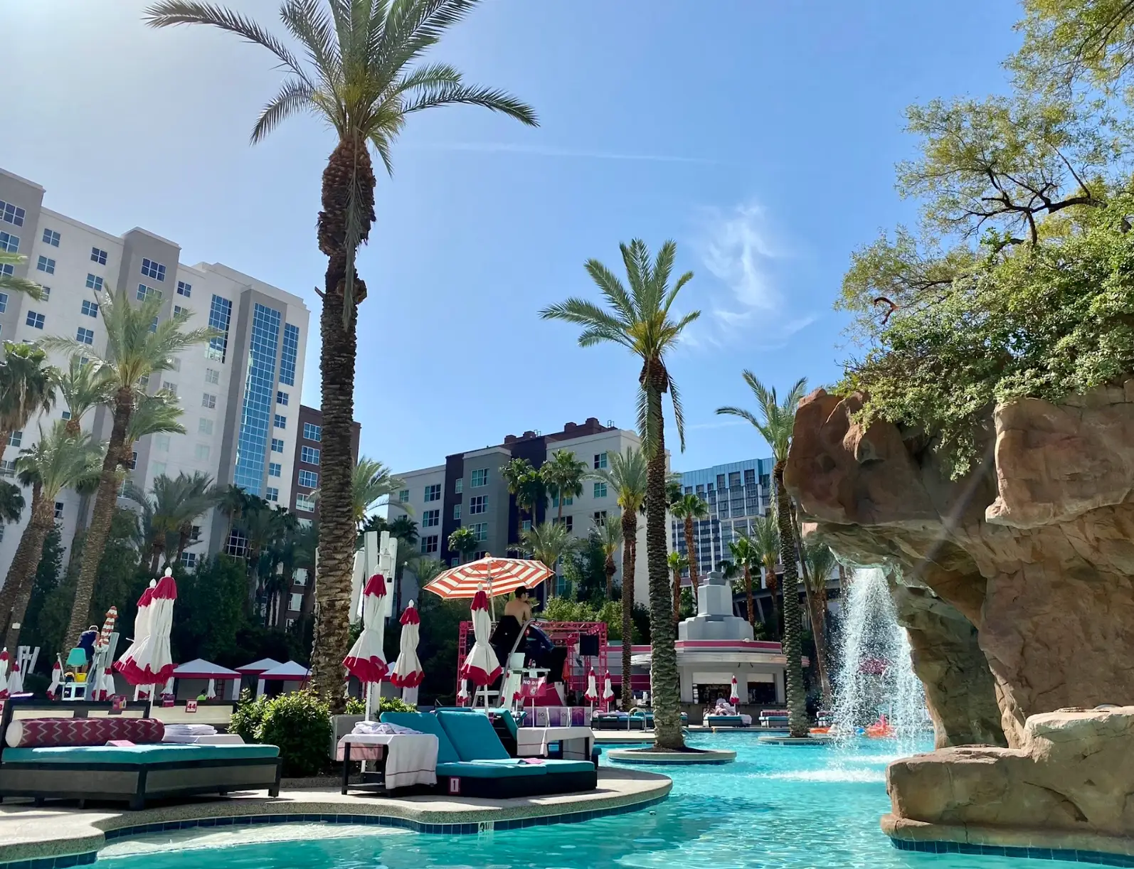 A pool at a hotel with palm trees around it.