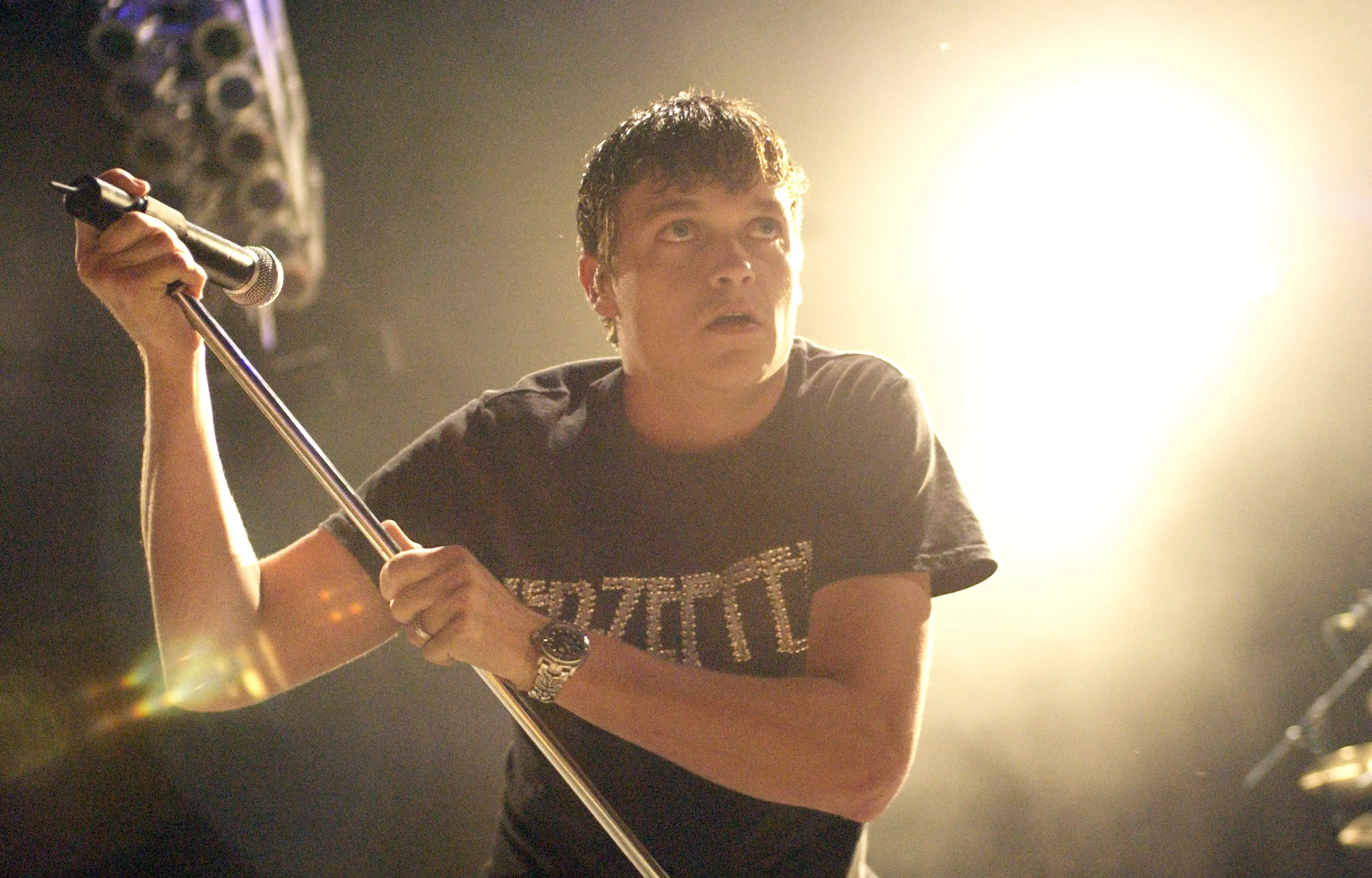 Brad Arnold leaning on a microphone stand