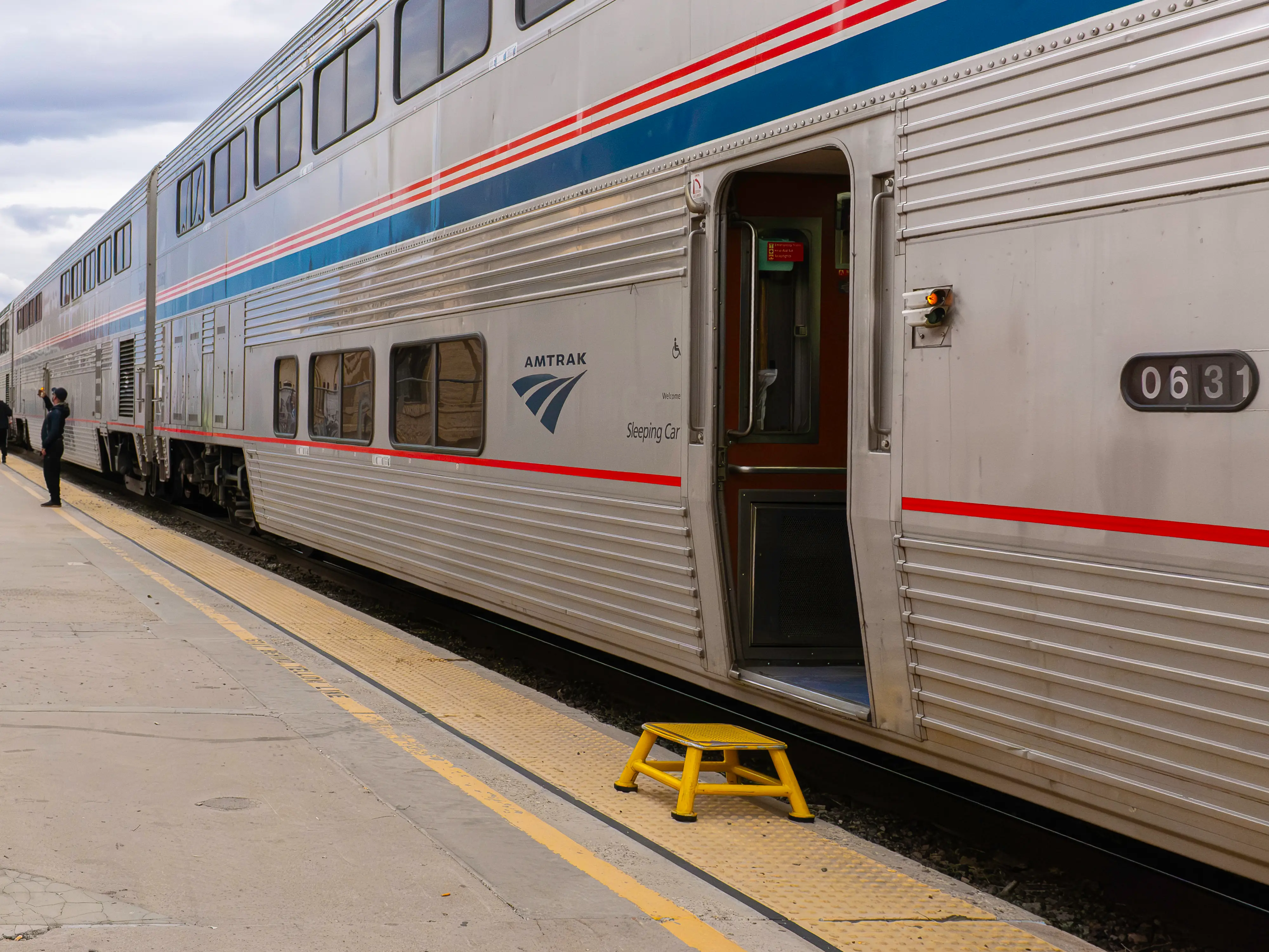 The exterior of a double-decker Amtrak Superliner train with red and blue stripes
