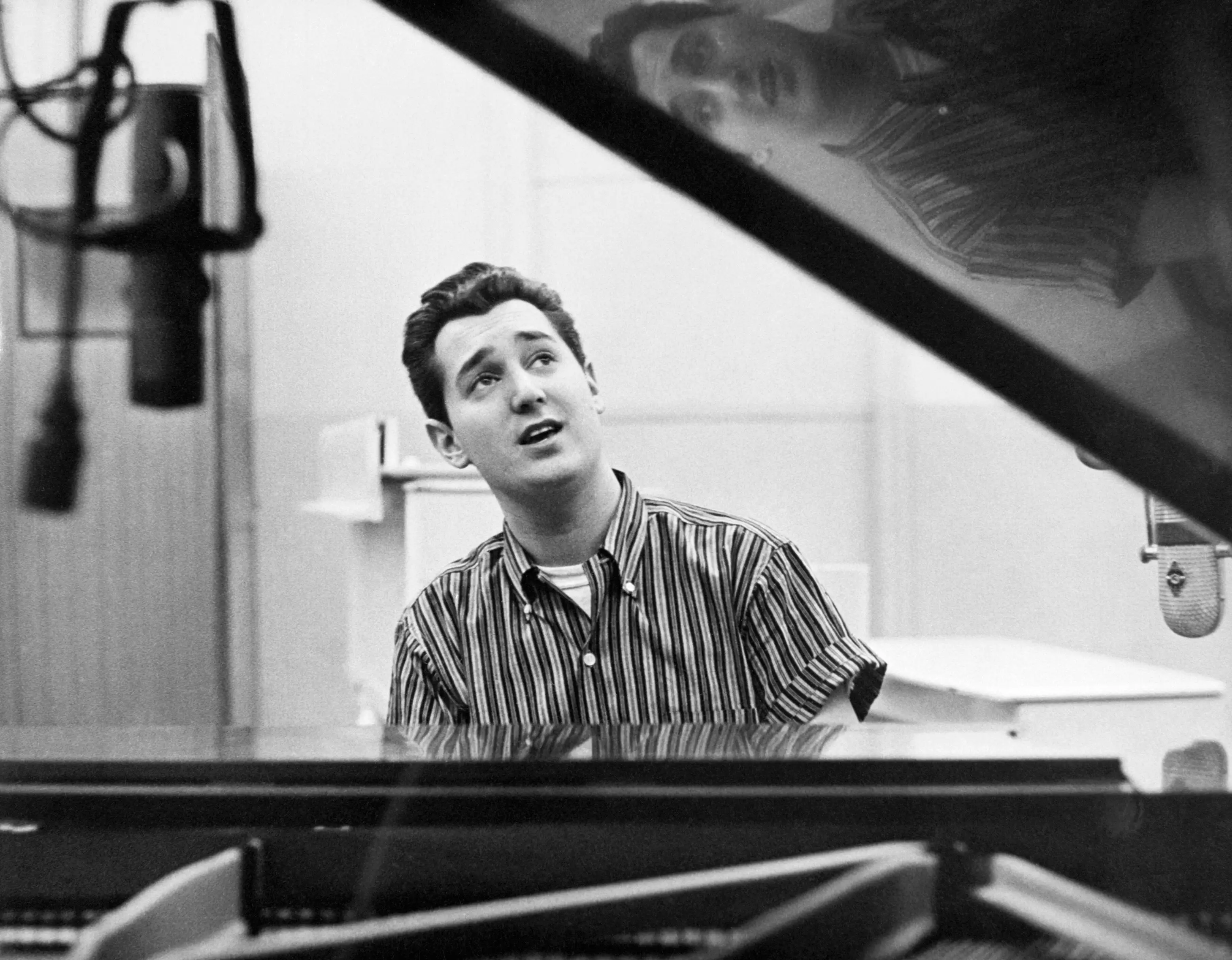 Neil Sedaka singing while sitting at a piano