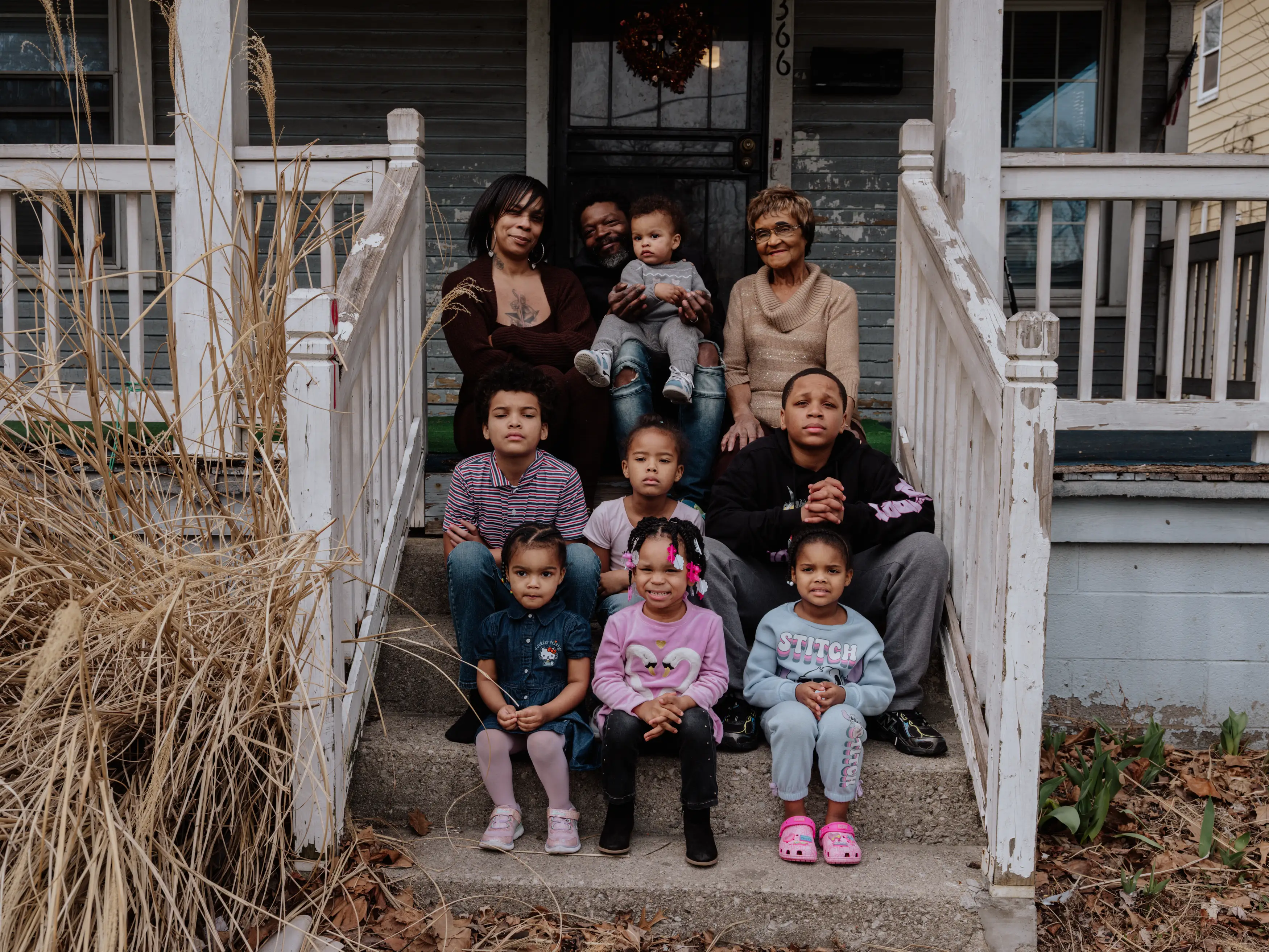 June Boyd's family sitting on the steps of their multigenerational house