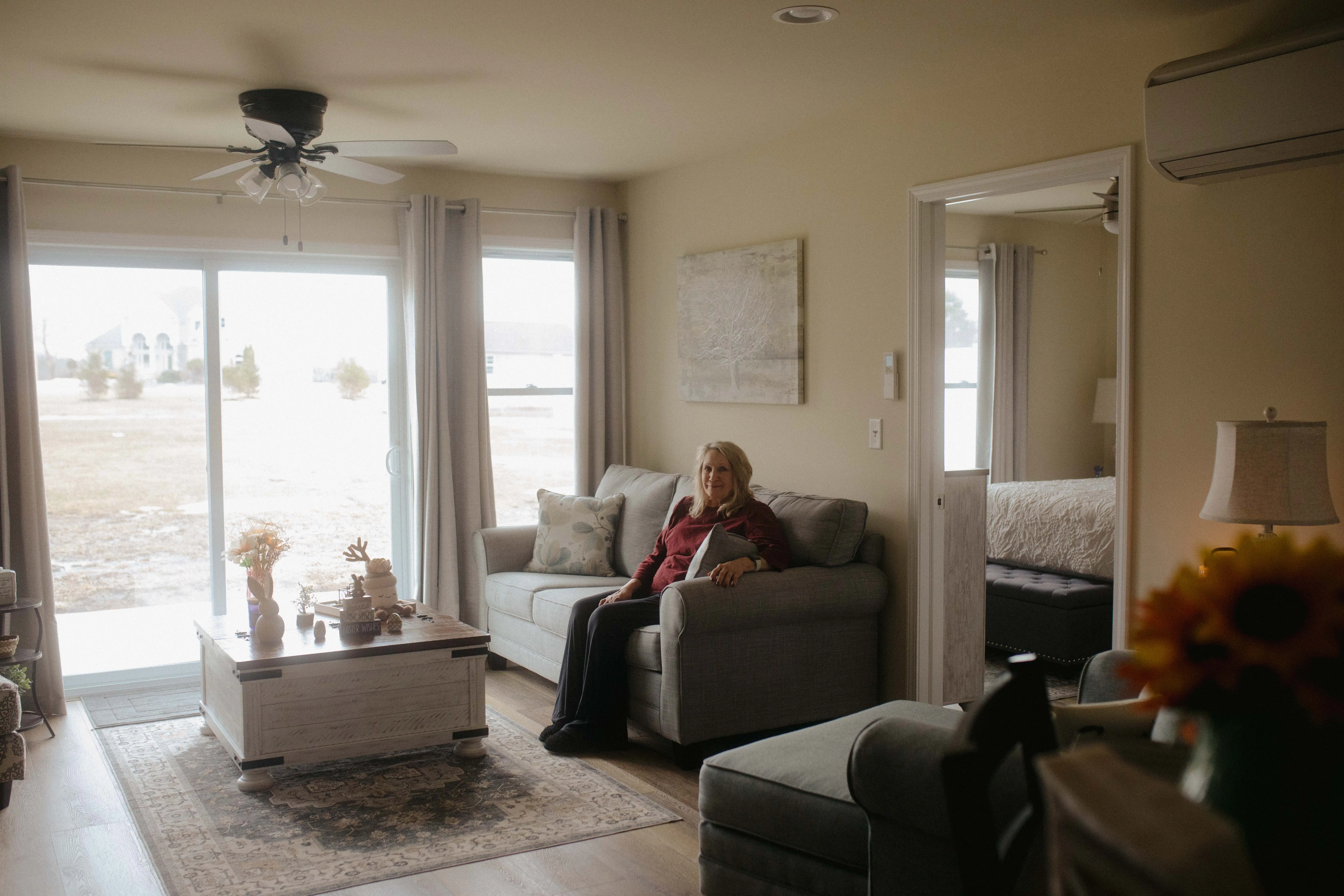 Jene Sena's mother sitting on a couch in her living room