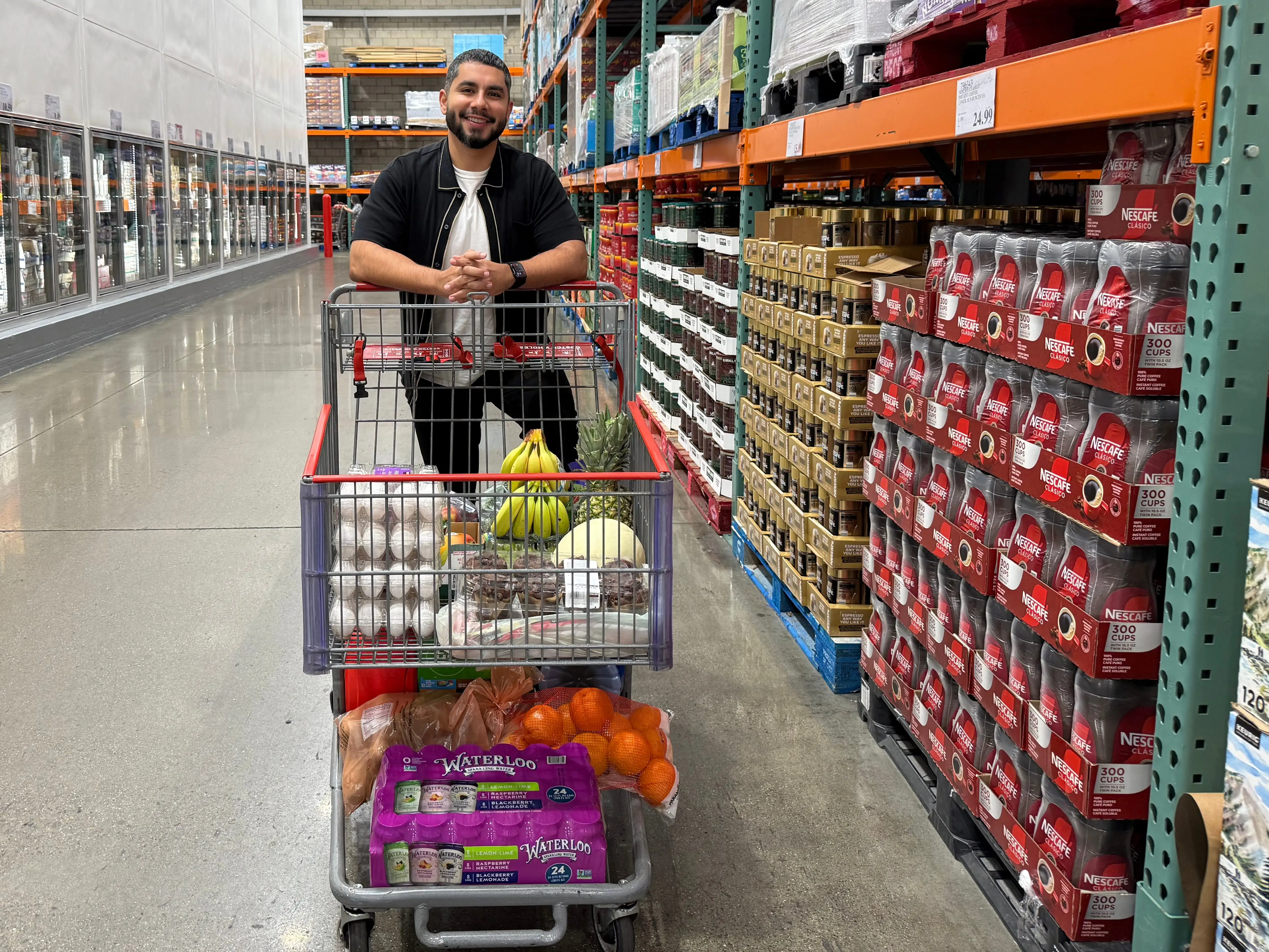 Man behind partially filled shopping cart in Costco Aisle