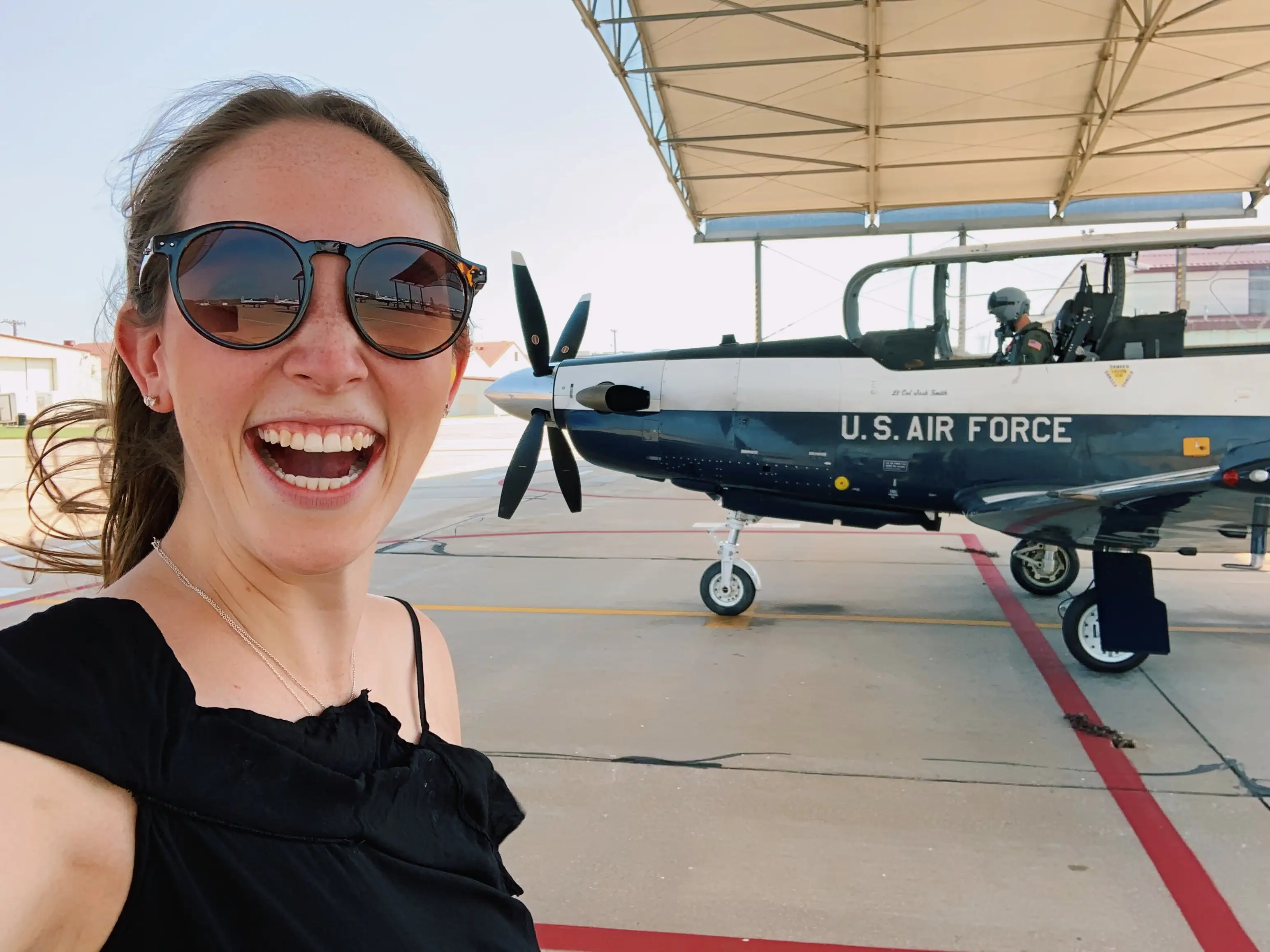 Woman smiling next to plane