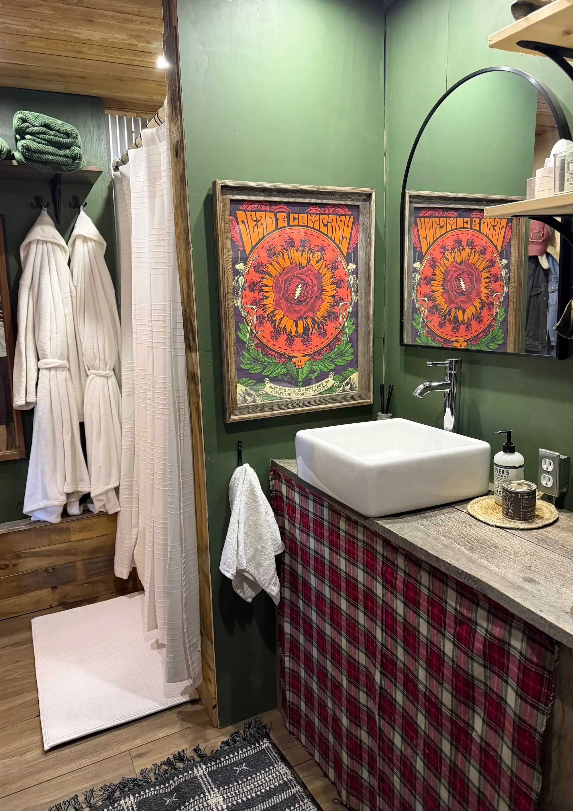 A vanity and shower. Robes hang from a hook.