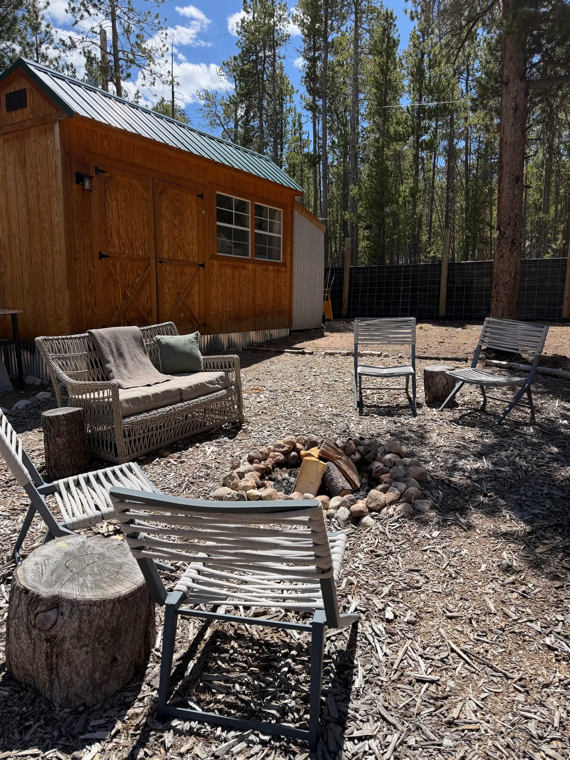A yard with a firepit and shed.