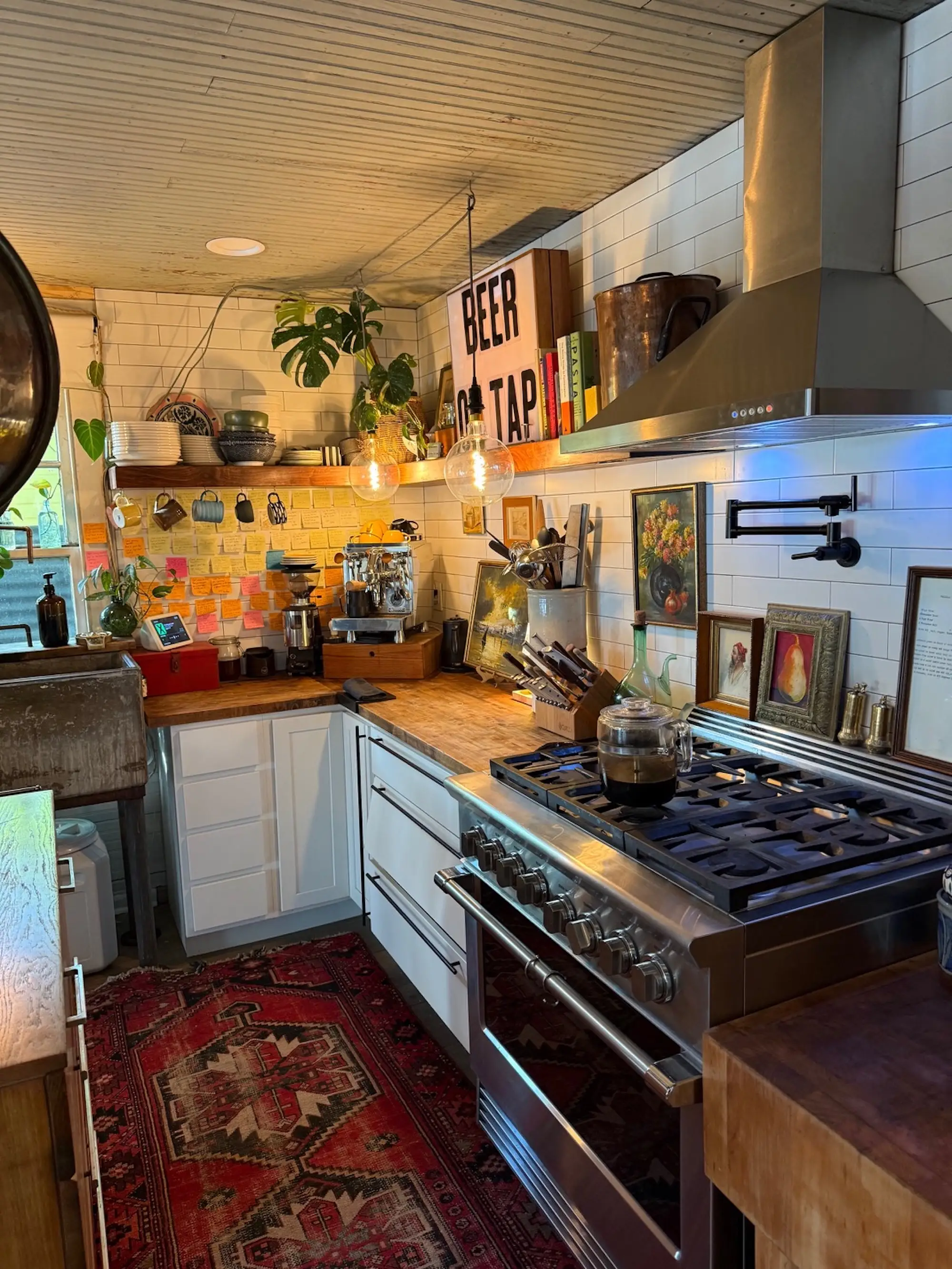 A kitchen with butcher block countertops and a stove with a vent hood.