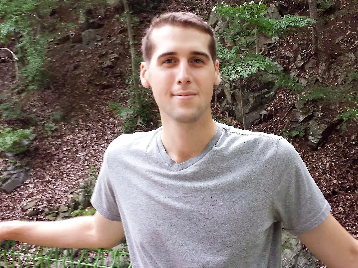 A man posing for a picture outdoors.
