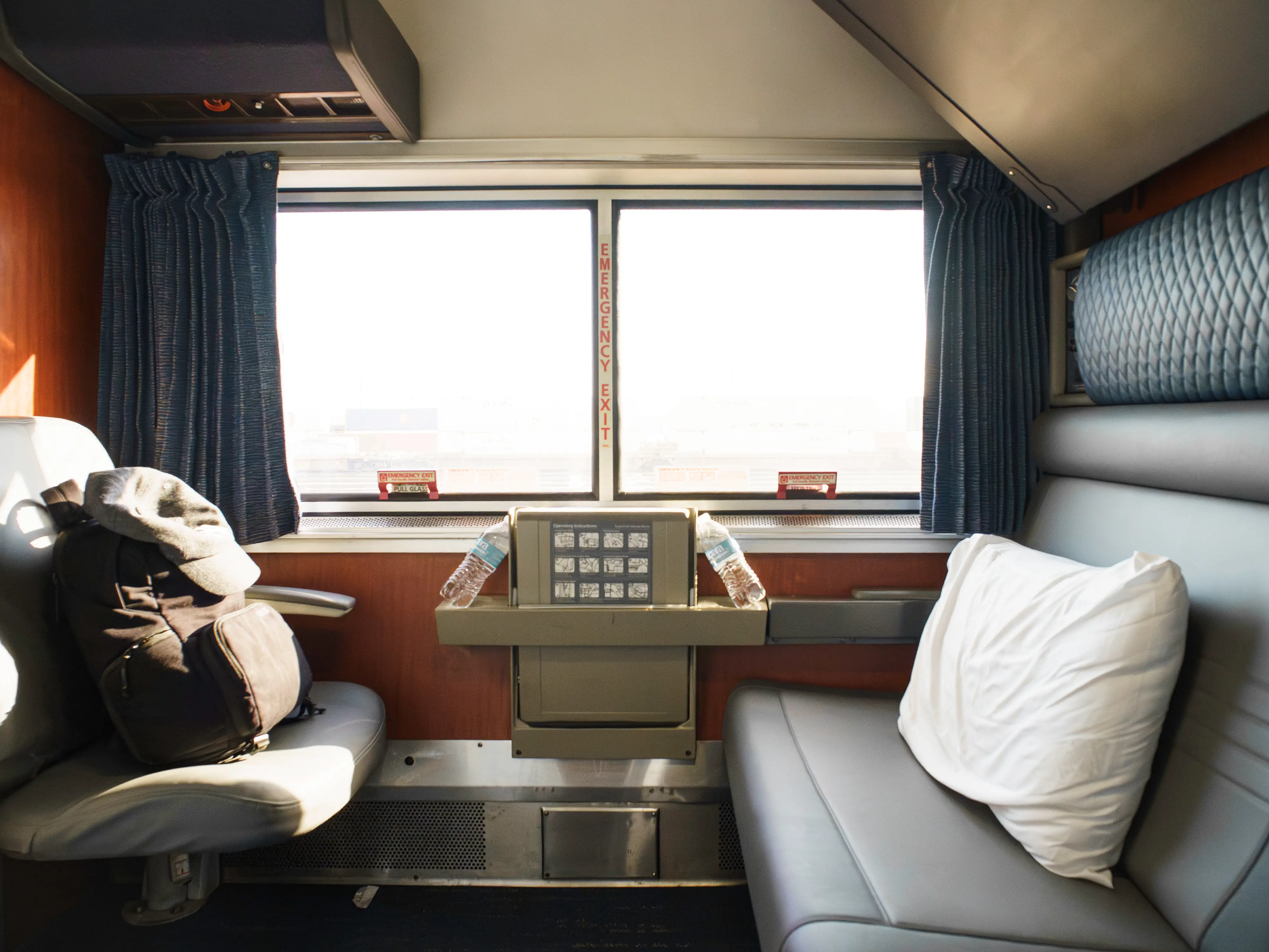 Inside an Amtrak bedroom with two seats across from each other in front of a wide window