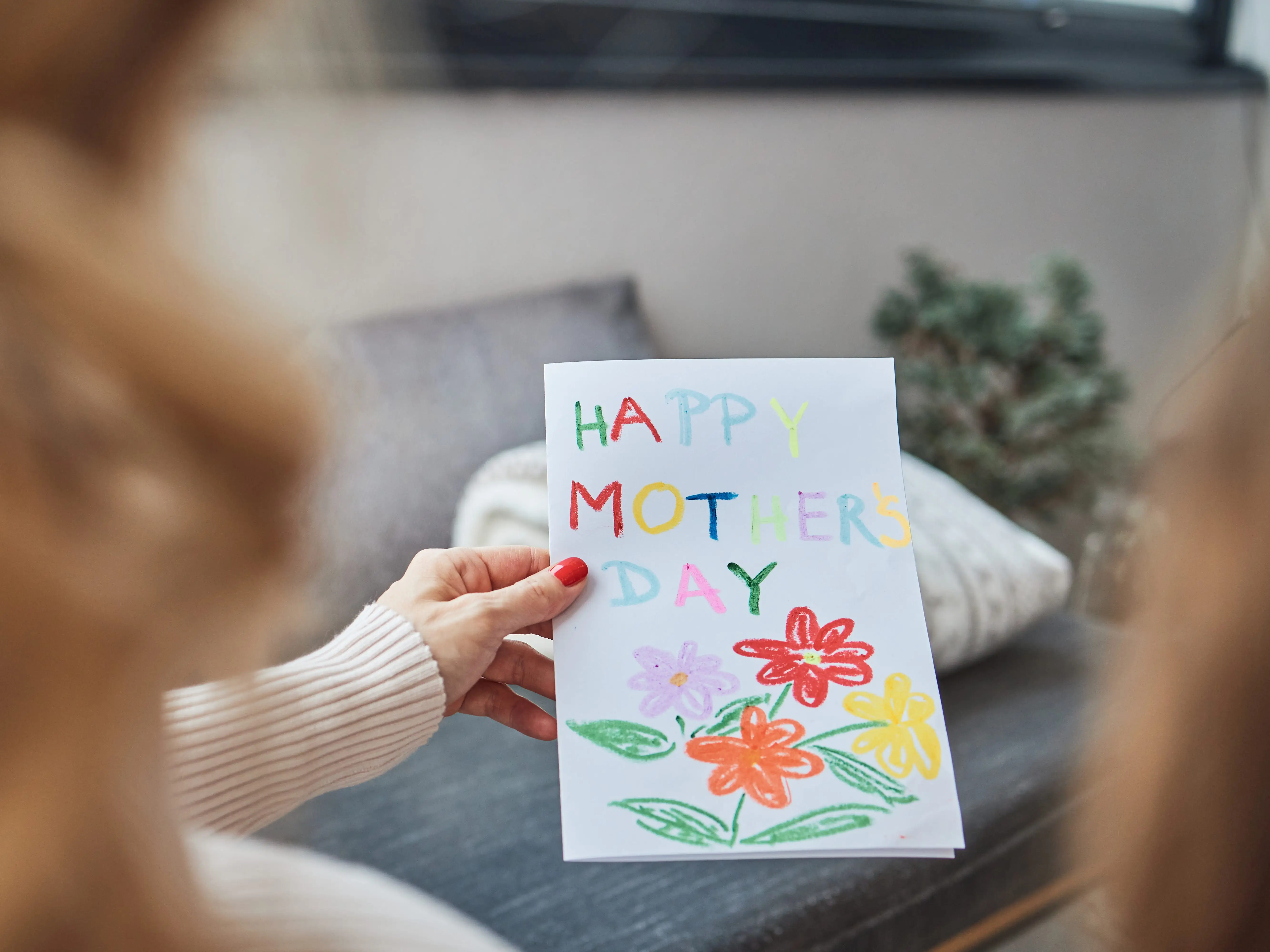 A woman holding a Mother's Day card.