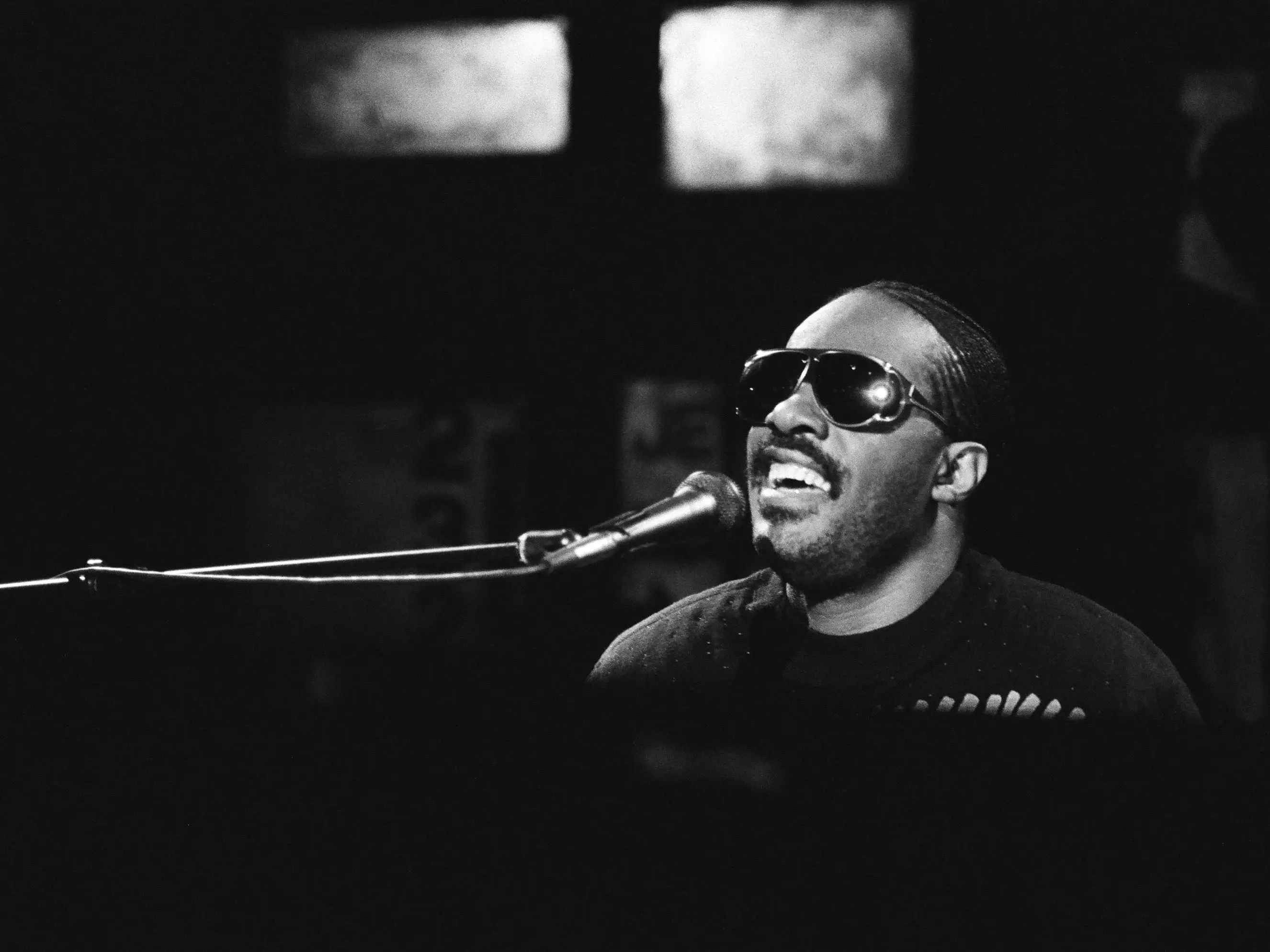 Stevie Wonder singing into a microphone.