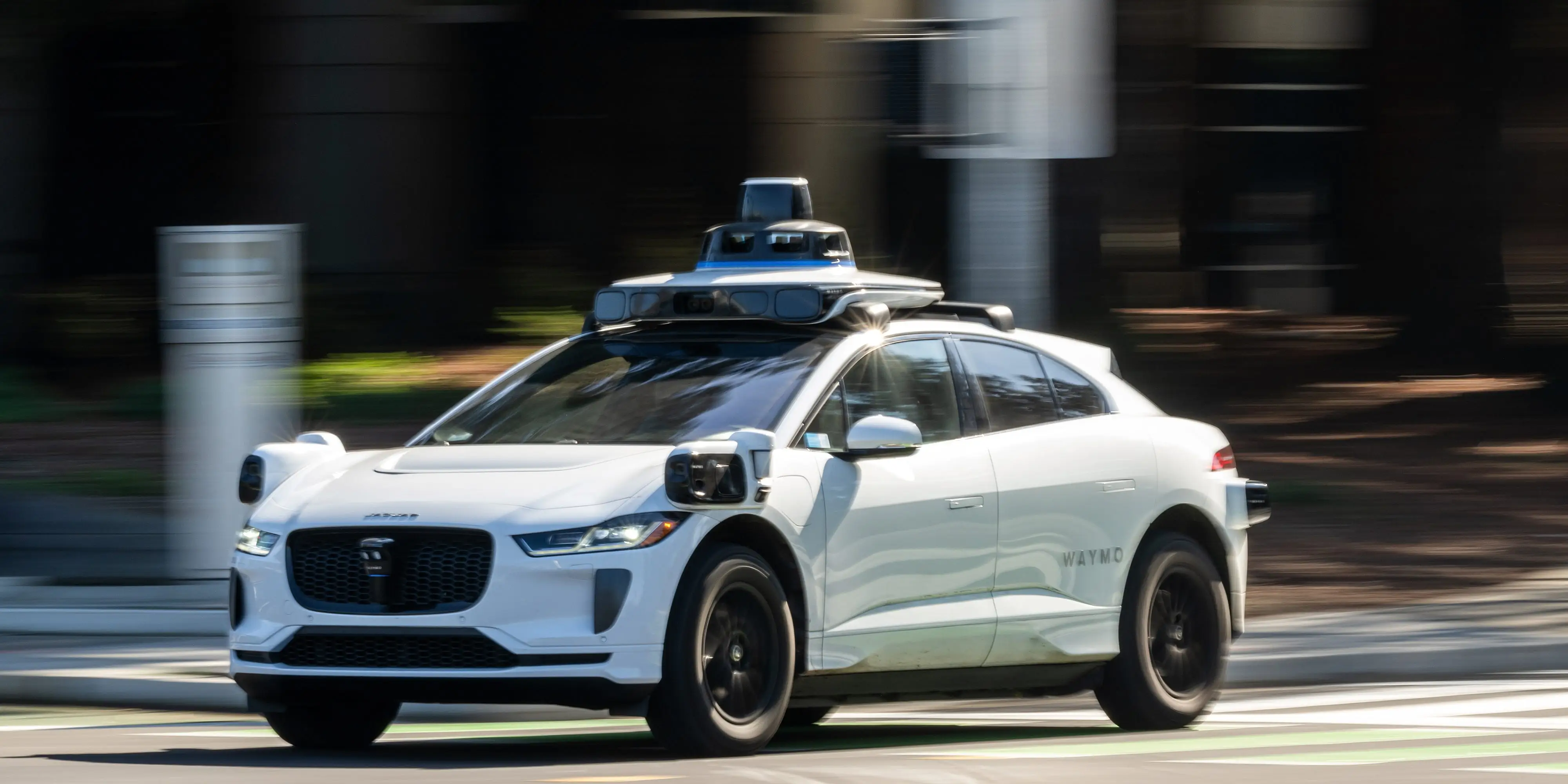 A Waymo robotaxi driving down a road
