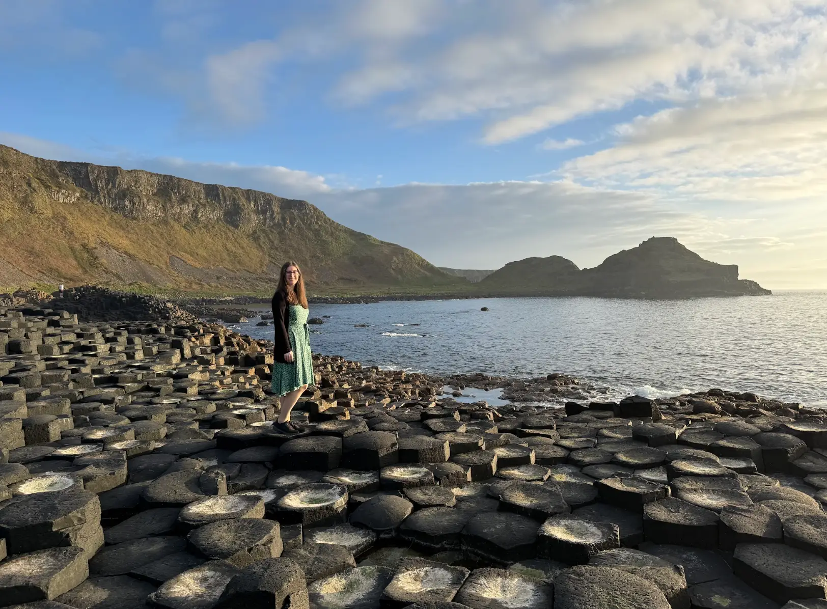 The writer standing on basalt columns overlooking the water in Northern Ireland.