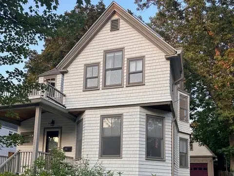 A detached home with a front yard full of flowers