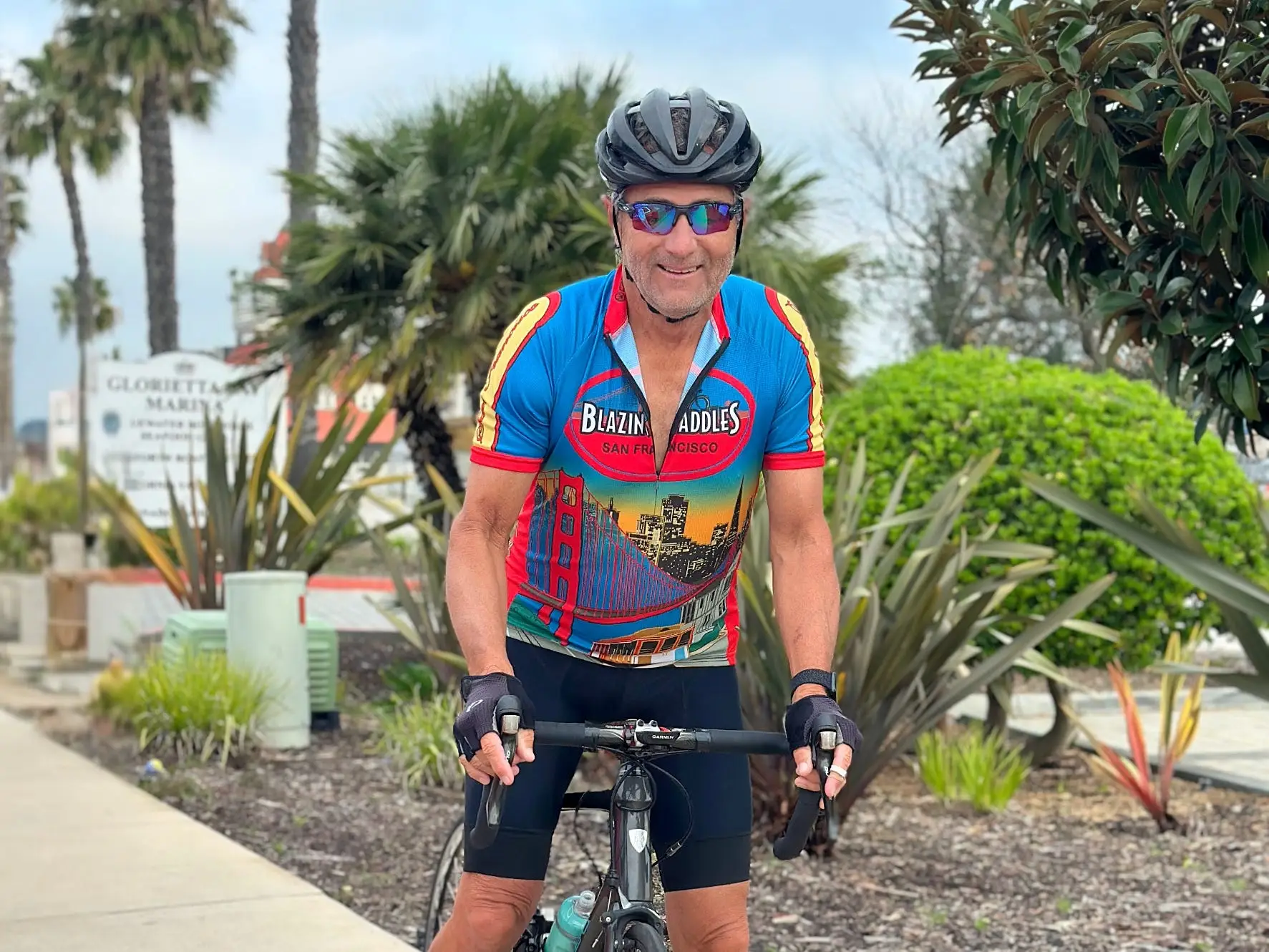 a man on a bike in colorful exercise clothing outside in California