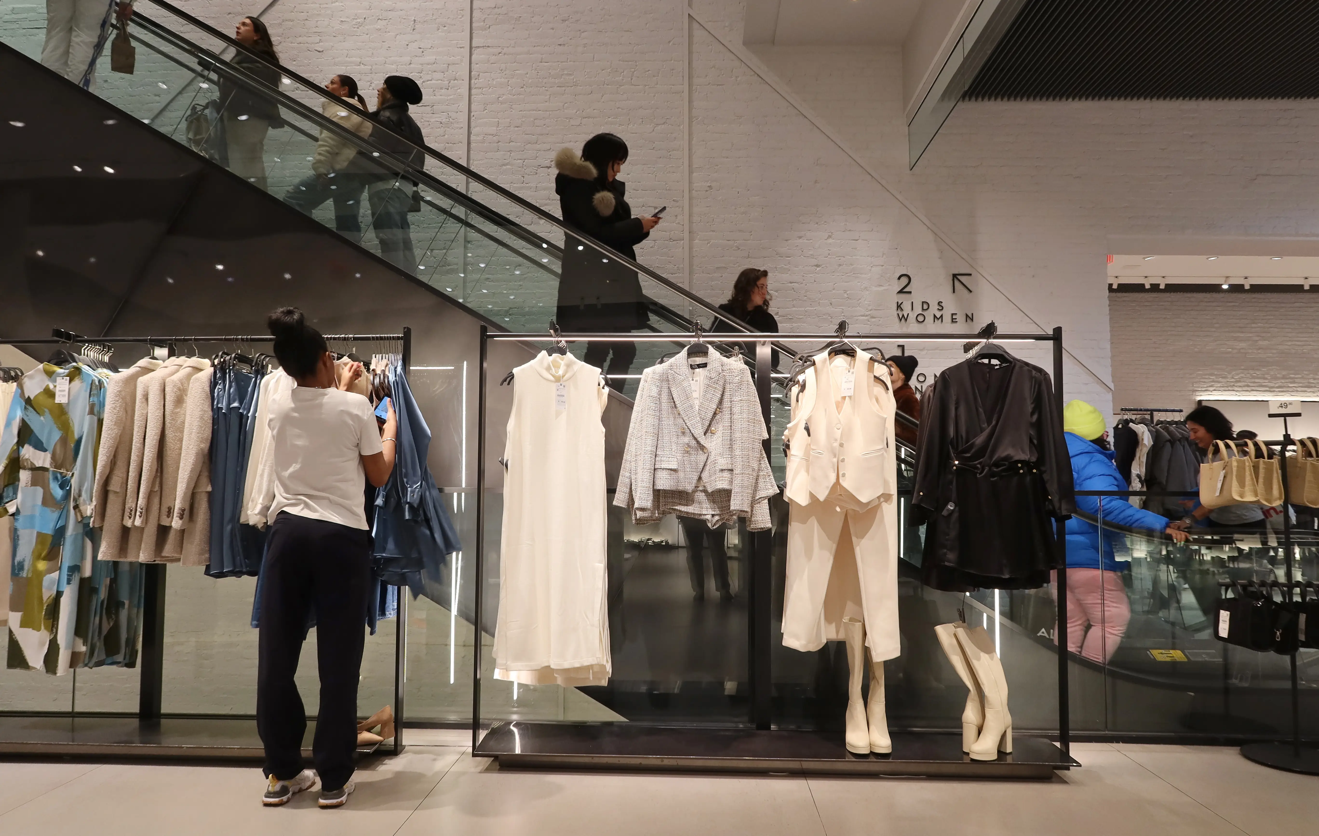 People shop for clothes at a Zara store.