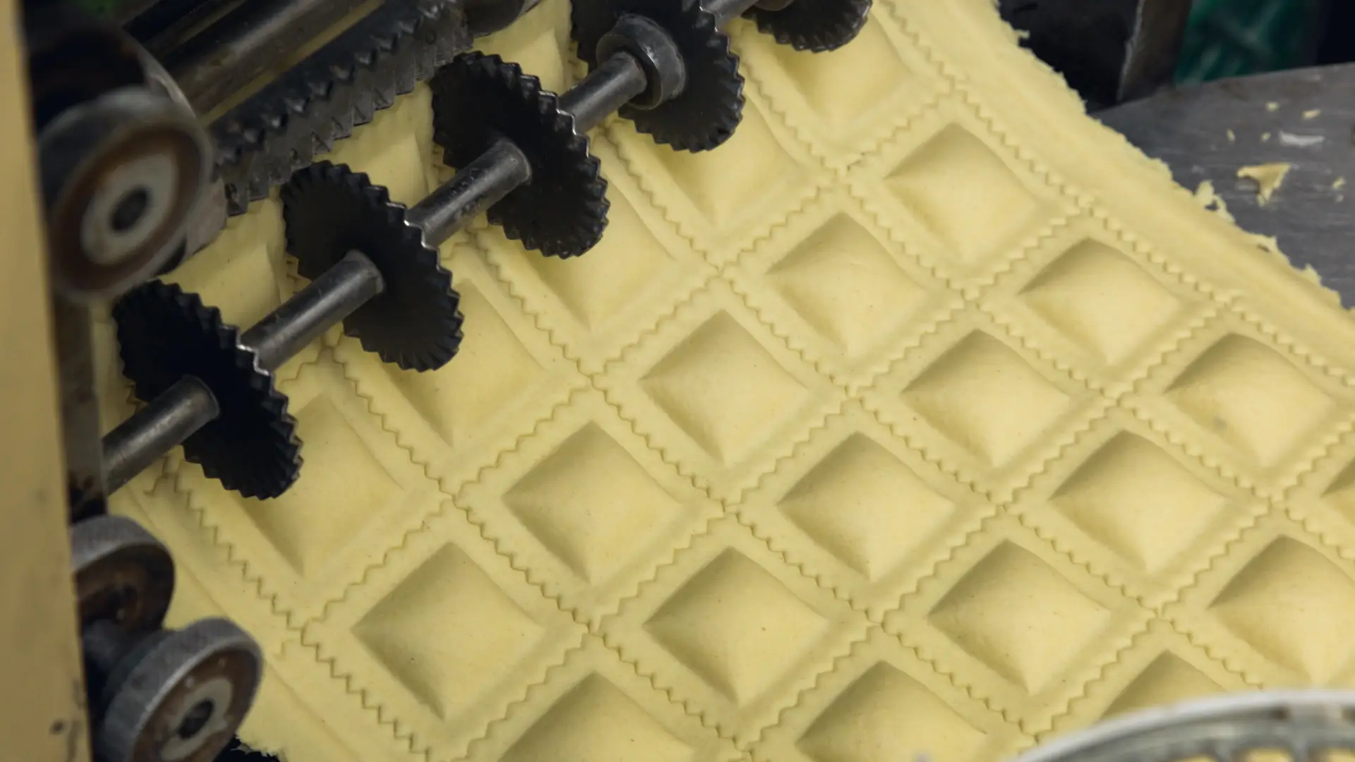 A ravioli machine cutting ravioli dough.