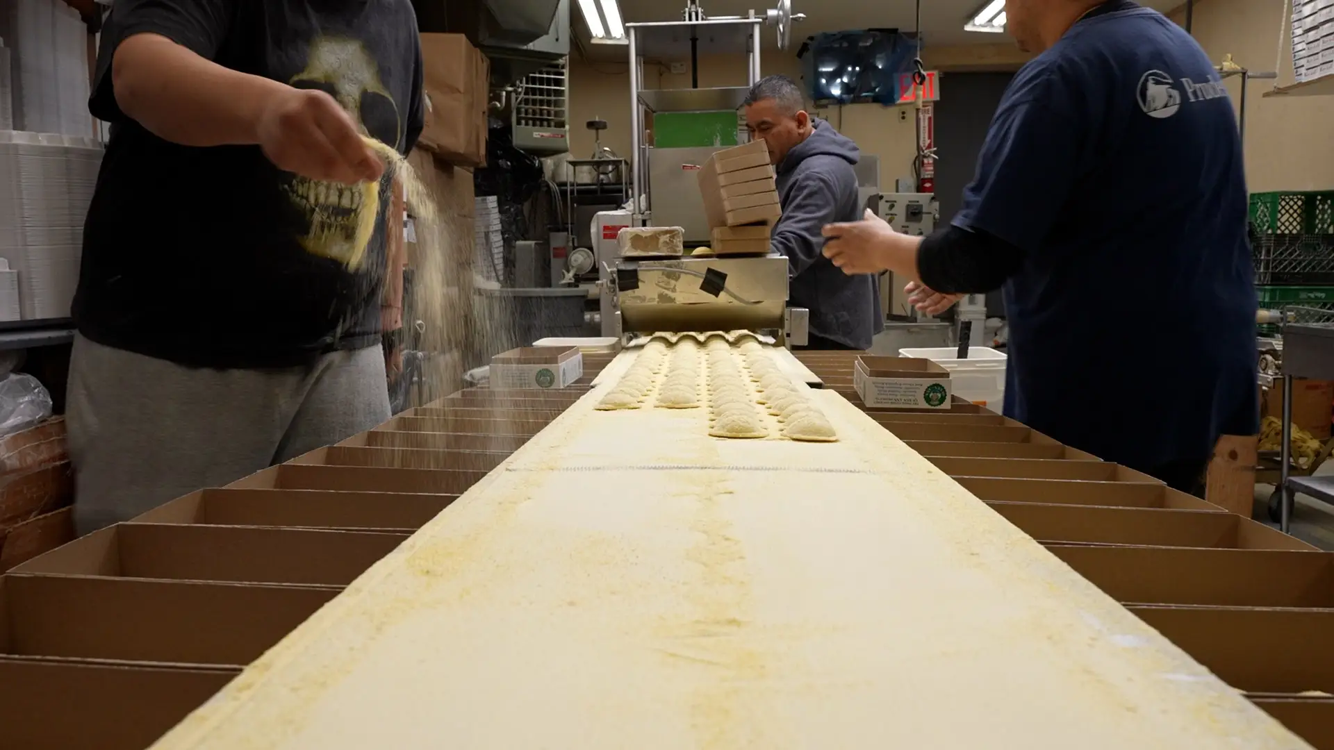 Individual raviolis on a conveyor belt.